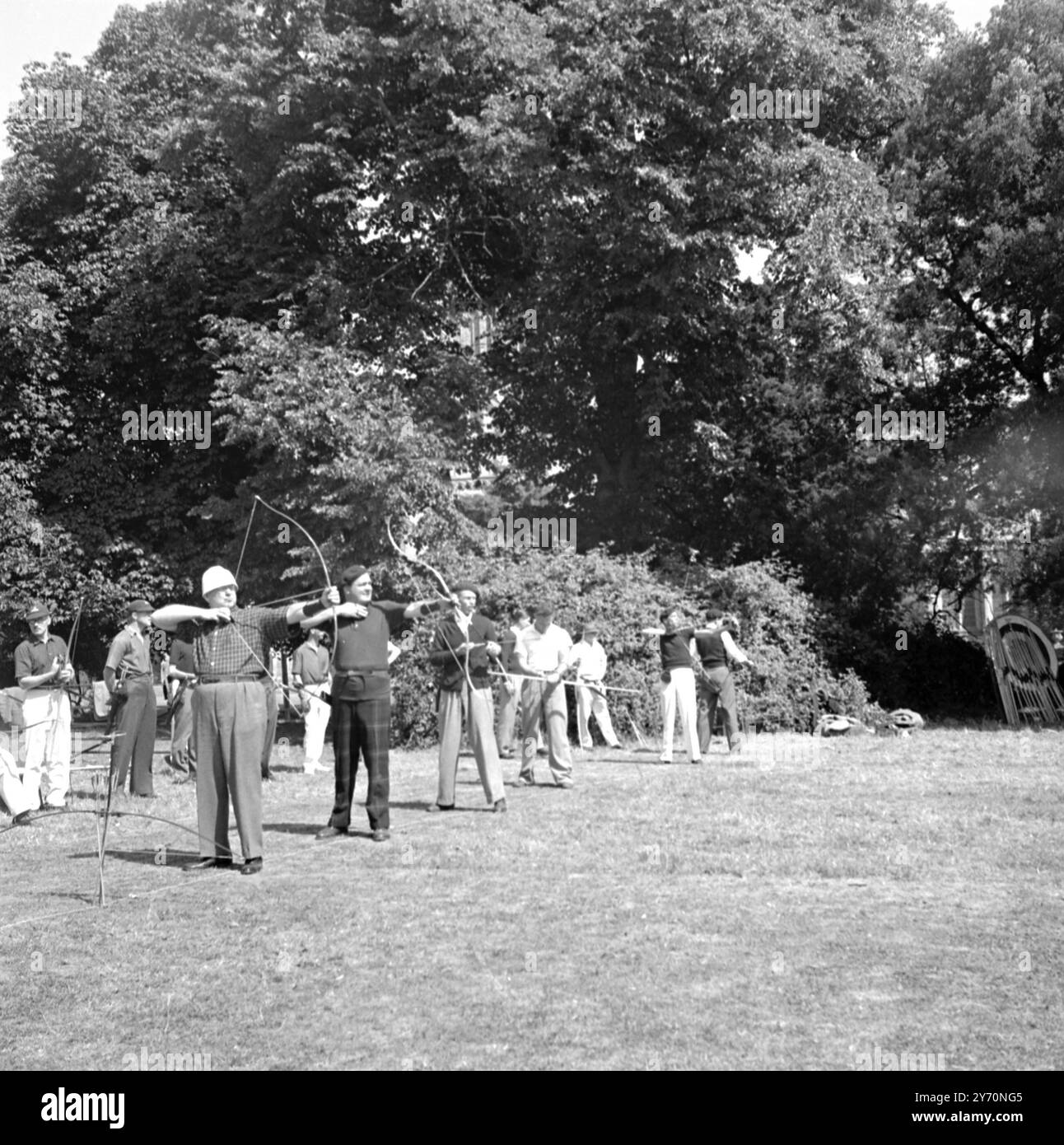 POZZI DI ' MODA ' questi arcieri, che condividono lo stesso 'scopo', sono altamente individualistici sul tema di ciò che il bowman intelligente dovrebbe indossare camicia a scacchi e pantaloni tartan sono considerati ugualmente appropriati! Gli uomini stanno prendendo parte alla 76a sparatoria annuale della Grand Western Archery Society nel terreno del Bishop's Palace di salisbury (Wilts). L'arciere in primo piano con il cappello bianco rotondo è Mr. Robert P.. Elma, ex campionessa americana e nota scrittrice di tiro con l'arco. 9 luglio 1949 Foto Stock