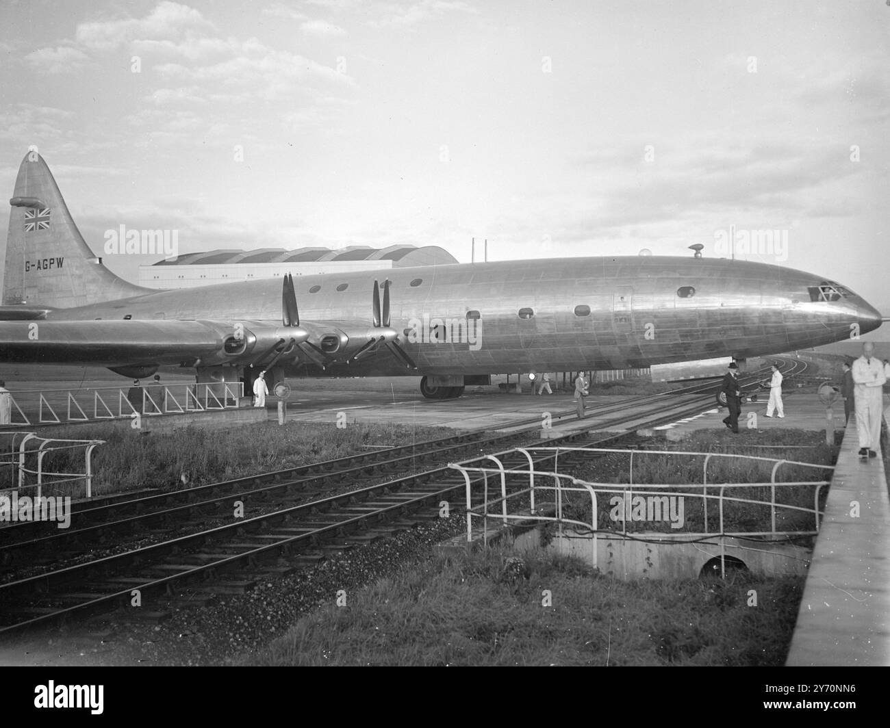 IL BRABAZON ATTRAVERSA LE LINEE FERROVIARIE poco dopo le sette e mezza di questa mattina, il più grande aeroplano civile del mondo di Brabazon, si trovava sulla pista di Filton, Bristol, lunga un miglio e mezzo, pronto per iniziare le prove di taxi. Fu trainato fuori dal suo enorme hangar da un trattore a sei ruote , e gli esperti controllarono lo spazio di manovra delle ali mentre il gigante aereo di linea si muoveva attraverso il piazzale , passando attraverso ampi cancelli gialli di passaggio a livello dove la linea ferroviaria Filton-Avonmouth attraversa la pista . L'IMMAGINE MOSTRA:- il ' Brabazon ' che attraversa il passaggio a livello che taglia la sua pista all'inizio di questo m Foto Stock