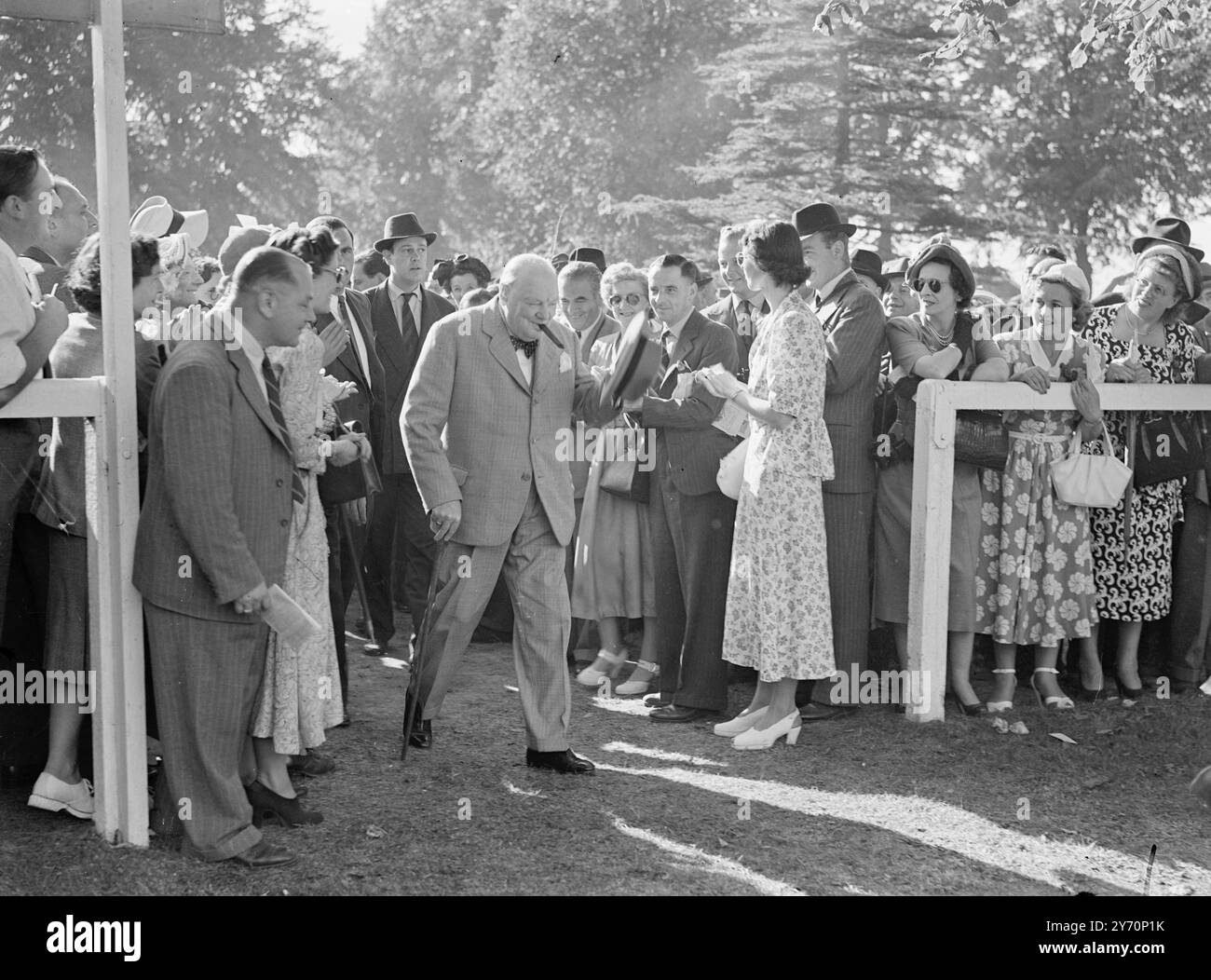 Il PROPRIETARIO VINCENTE, il signor Winston Churchill, sigaro in bocca e fascio felicemente, getta il cappello agli applausi dei piloti di Windsor oggi, quando il signor Il colonista di cavalli di Churchill II ha vinto la posta in palio del tiglio. Signor Churchill era all'estero quando il colono II portò i suoi colori alla vittoria per la prima volta come Sailsbury di recente. 11 settembre 1949 Foto Stock