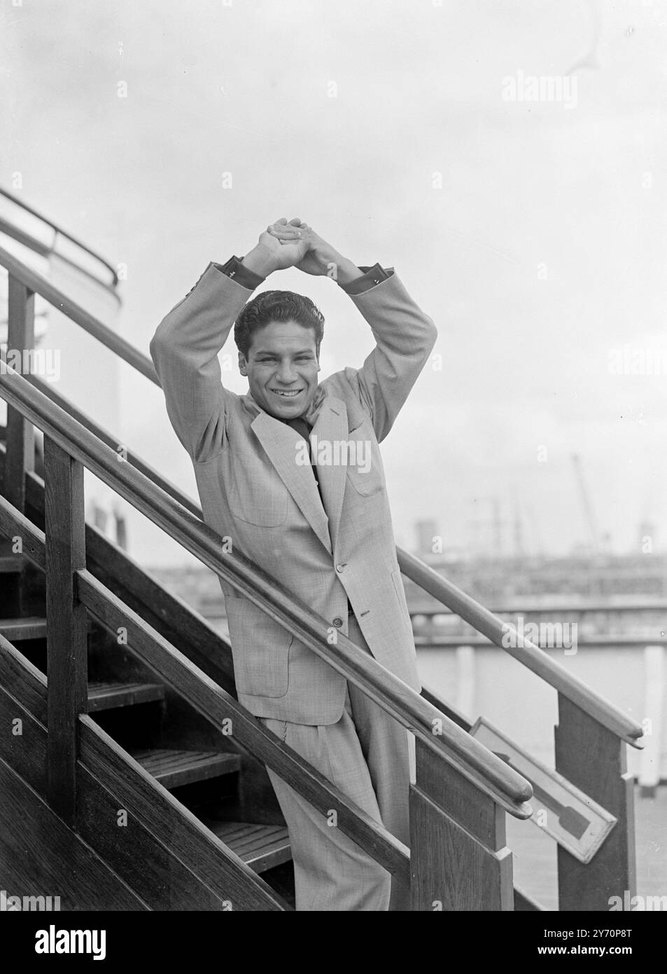 IN QUESTA IMMAGINE ..... MANUEL ORTIZ... Il messicano ORTIZ, campione del mondo dei pesi bantam, è arrivato oggi in Inghilterra a bordo della Cunard White star liner ' Queen Elizabeth ' che ha attraccato a Southampton. La sua prima gara in questo paese sarà contro il campione britannico dei pesi piuma Ronnie Clayton, una partita in sovrappeso, che andrà in scena a Belle vue , Manchester, il 3 ottobre. Ortiz - ha 32 anni-potrebbe successivamente decidere di difendere il suo titolo mondiale qui . LE IMMAGINI MOSTRANO:- Manuel Ortiz, campione del mondo dei pesi gallo, adotta un "entrando nel ring" quando è arrivato a Southampton a bordo del Qu Foto Stock