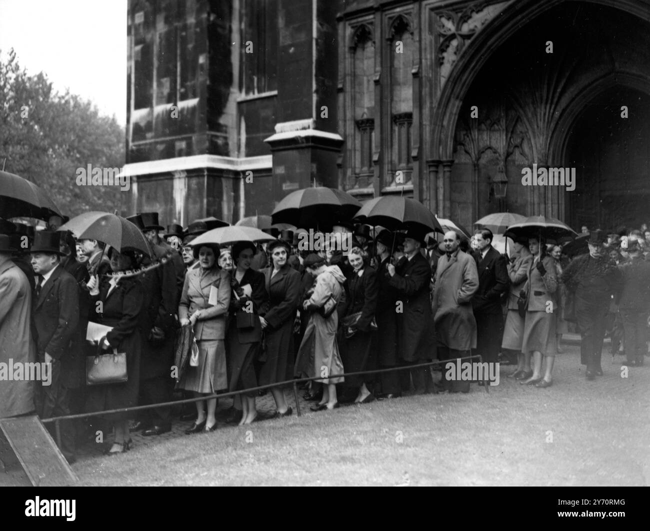 Folle di ombrelloni fotografate oggi fuori dall'Abbazia di Westminster per vedere l'arrivo e la partenza dei numerosi illustri personaggi che hanno partecipato al servizio commemorativo svoltosi qui oggi per il generale Smuts , la cui morte ha privato il Sudafrica di una delle sue figure politiche più importanti .26 settembre 1950 Foto Stock