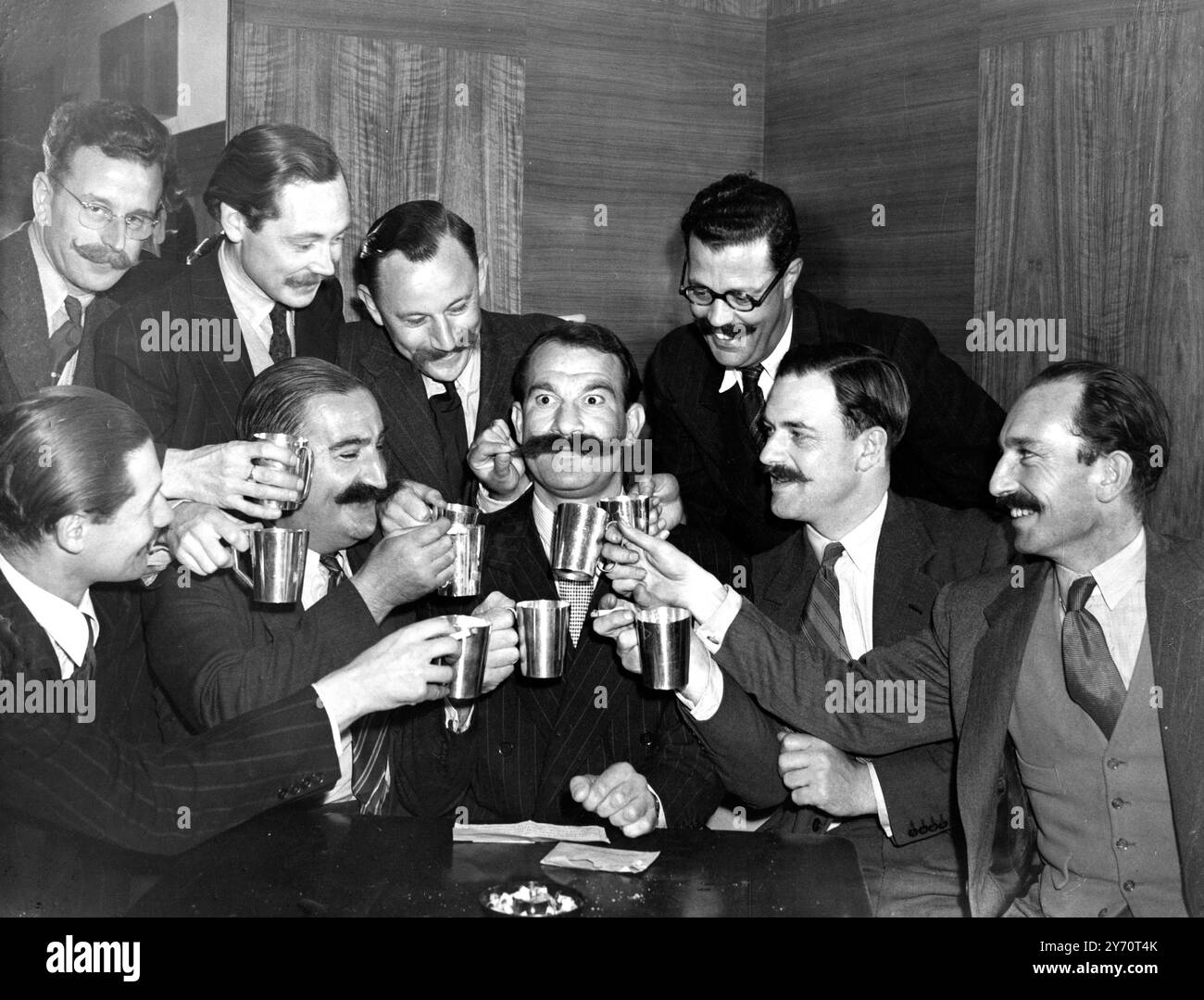 Il Club dell' Handlebar - la cui appartenenza è limitata ai baffi con ' arti afferrabili' , sta perdendo il suo ' prime Handlebar' . Titolare del titolo di Goerge Hoffman di St Albans emigra in Canada e porta con sé i suoi 1/4 pollici di baffi. Immagini: I membri del Club dell'Handlebar brindano George Hoffman i cui baffi sono legati al Canada . 16 giugno 1948 Foto Stock