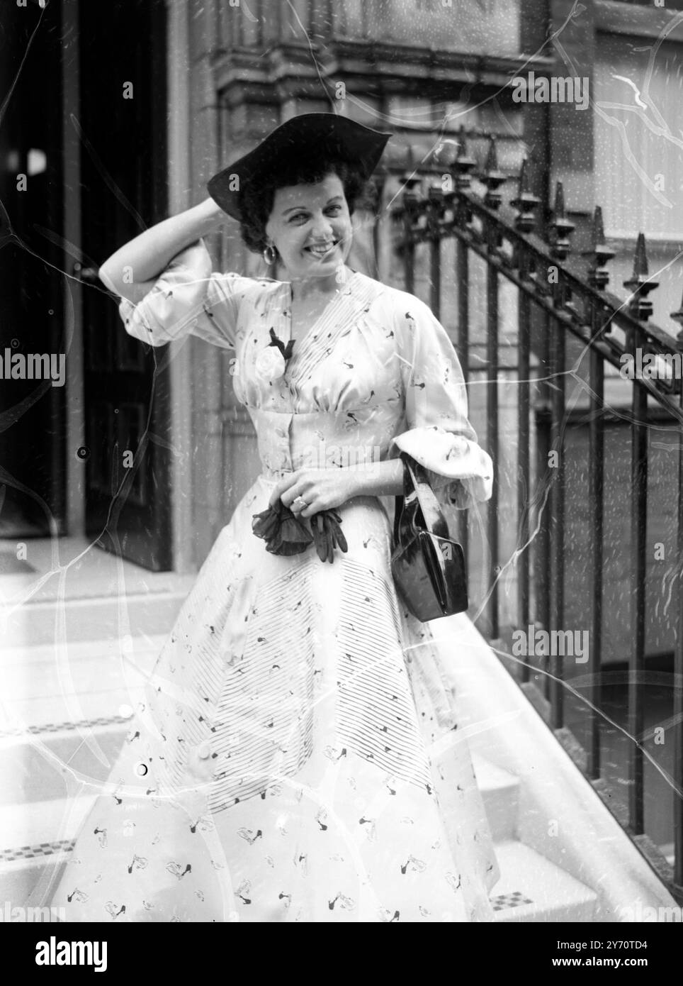 Lizbeth ha cambiato idea e vestito. Londra: In questo grazioso abito, l'attrice Lizbeth Webb stava per partire per Ascot dalla sua casa di Baker Street. Lo è stato, fino a quando non ha iniziato a piovere . Poi Lizbeth si voltò , andò di nuovo in casa e tornò indossando una creazione più severa più adatta al clima dubbioso di oggi . 17 giugno 1954 Foto Stock