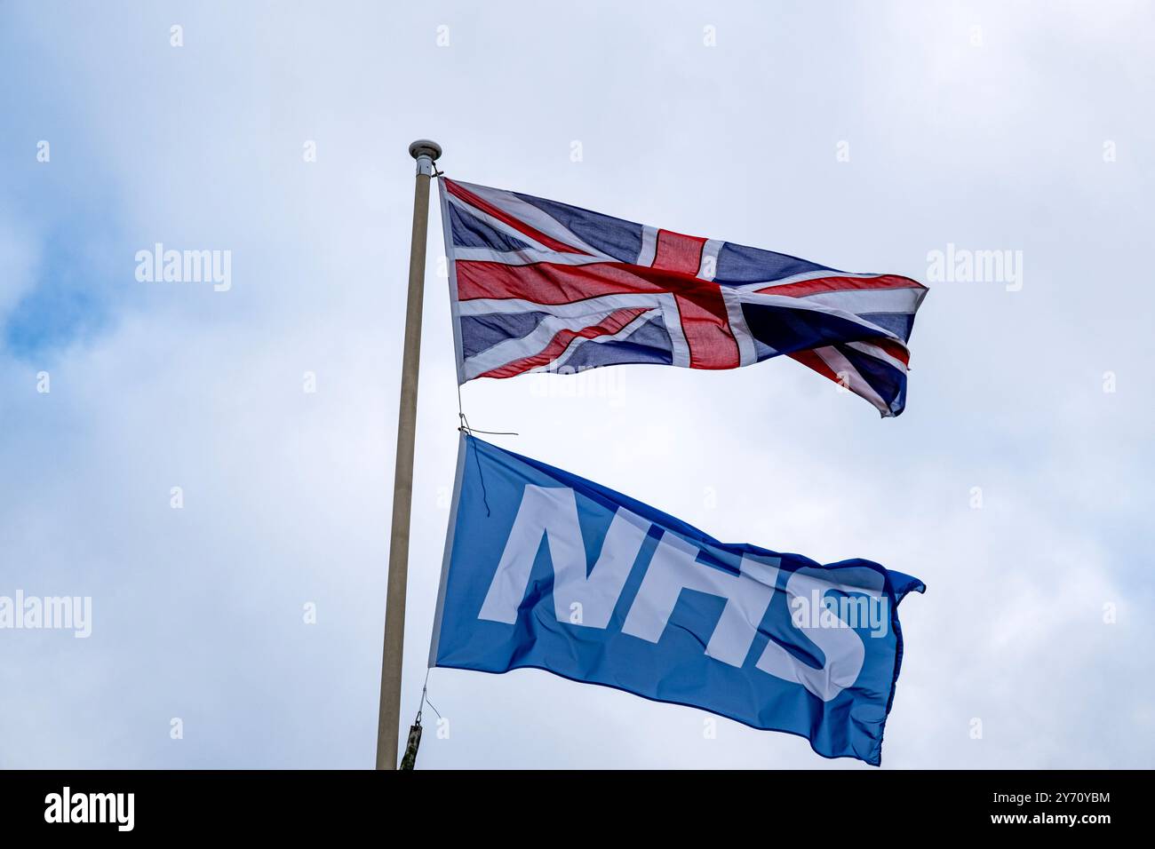 Union Jack con bandiera NHS isolata contro il cielo Foto Stock