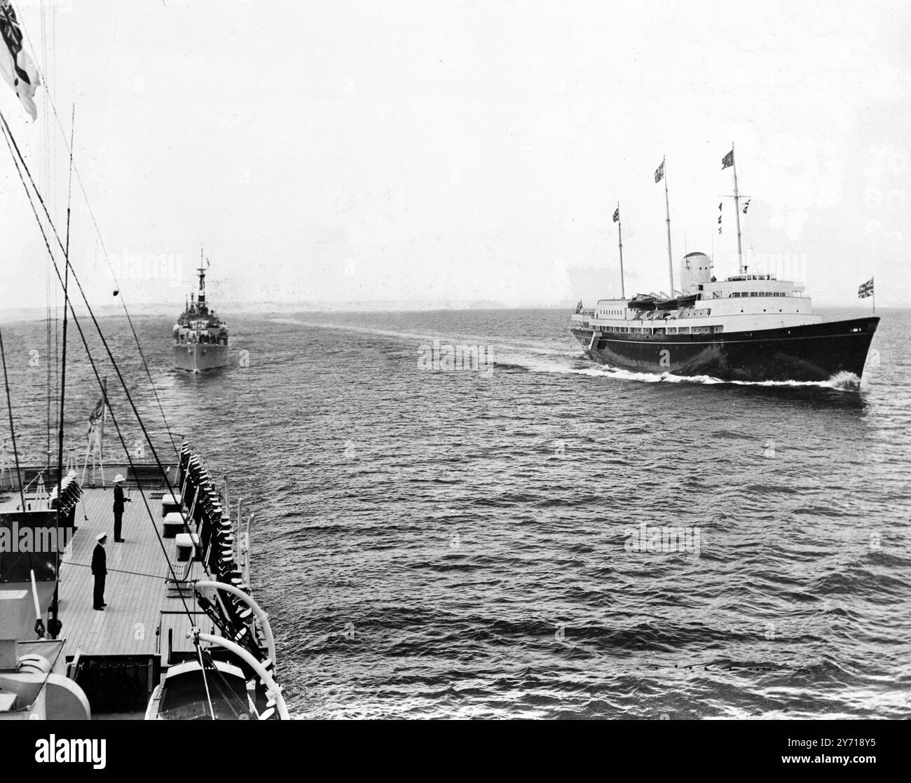 Il Royal Yacht Britannia sorpassa la HMS Surprise dopo aver lasciato Tobruk per Malta ( 1° maggio 1954 ) . Alcune delle compagnie della nave possono essere viste un saluto sul ponte della sorpresa .3 maggio 1954 Foto Stock