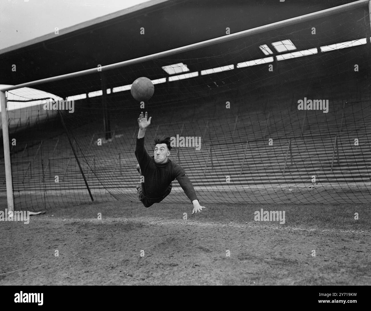 TUTTA LA determinazione DELLO SFORZO è rappresentata sul volto del portiere del Newcastle United - il portiere JACK FAIRBROTHER , che viene raffigurato saltare in azione nel disperato tentativo di impedire un gol , . Fairbrother è nativo del Derbyshire ed è alto 5 piedi 11' e pesa 12 st 11 libbre . Fu assicurato dal Newcastle dal Preston North End nel luglio 1947 a una cifra record per il Newcastle di £ 8, 000. Un portiere di prima classe , l' ambizione dei Jacks è di mantenere il gol per l' Inghilterra contro la Scozia . Sposato e padre di due figli, il suo hobby principale è la lezione, e i suoi servizi sono ricercati dai club giovanili di tutto il paese Foto Stock