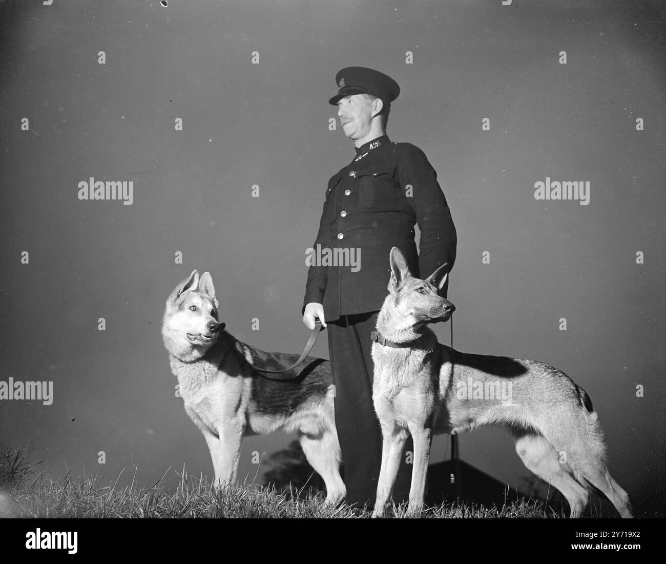 SORVEGLIANO IL POSSENTE BRABAZON -- CAMMINANO ( E GUARDANO ) DI NOTTE . Allerta sul loro lavoro , JACK e KELIN sono due dei cinque alsaziani sul libro paga della Bristol Aeroplane Company -- per aiutare il poliziotto di pattuglia a sorvegliare i potenti aerei britannici Brabazon . 21 febbraio 1949 Foto Stock