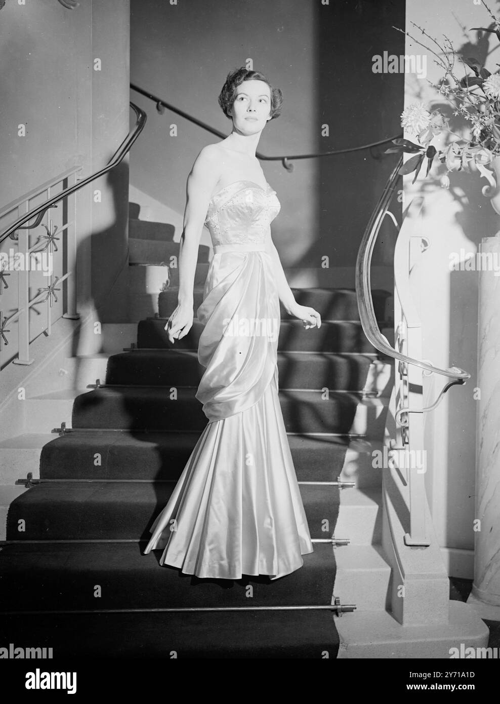 ELEGANZA LIBERALE NELLA MODA l'ultima recluta dell'industria della moda londinese, il canadese francese di 27 anni, GASTON MALLET, figlio di un liberale canadese, ha esposto i suoi stili a Londra. Le sue idee liberali sul fashion design si rivolgono più all'elegante che allo starling come prova della collezione di oggi '' che va verso una linea più dritta ''. Convinto che poche donne apprezzino i colori che meglio si addicono a loro , i suoi preferiti sono il nero , il grigio e il beige . Gaston fu addestrato dal famoso designer francese, Balmain. IMMAGINI MOSTRA :- una delle mode mostrate dal designer Gaston mal Foto Stock
