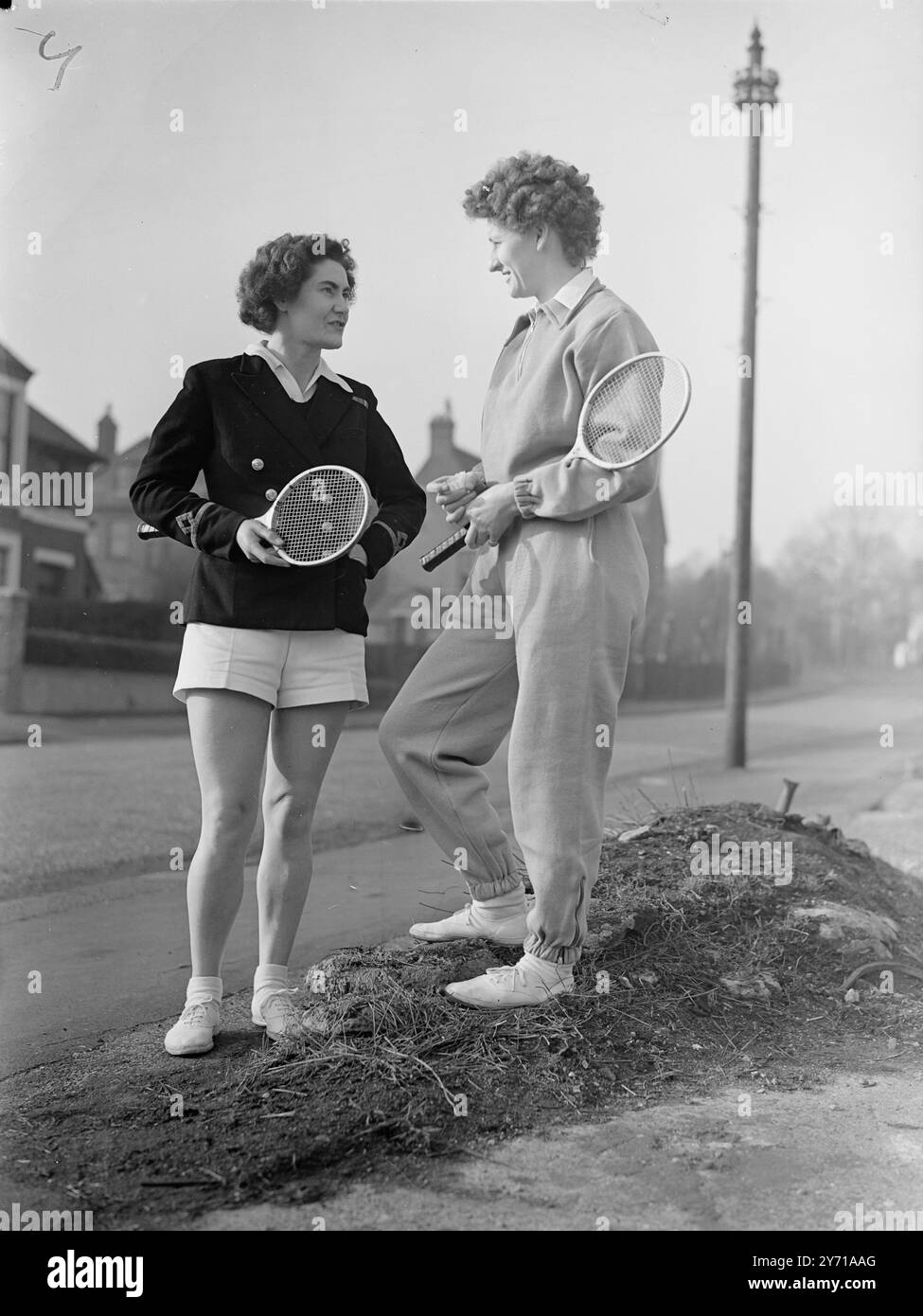 LE RAGAZZE DI SERVIZIO COMPETONO AI CAMPIONATI DI BADMINTON le giocatrici di Badminton sono venute a Wimbledon da tutte le parti della Gran Bretagna per competere nel primo inter-Service Badminton Championships da quando le forze femminili hanno ricevuto il loro nuovo status. IMMAGINI :- contrasto abito - Sgt . E.C. PARSONS . W.R.A.F. ( a destra ) e 3° ufficiale K . TURNER chiacchierava insieme prima di andare in campo per competere nei campionati . 11 febbraio 1949 Foto Stock