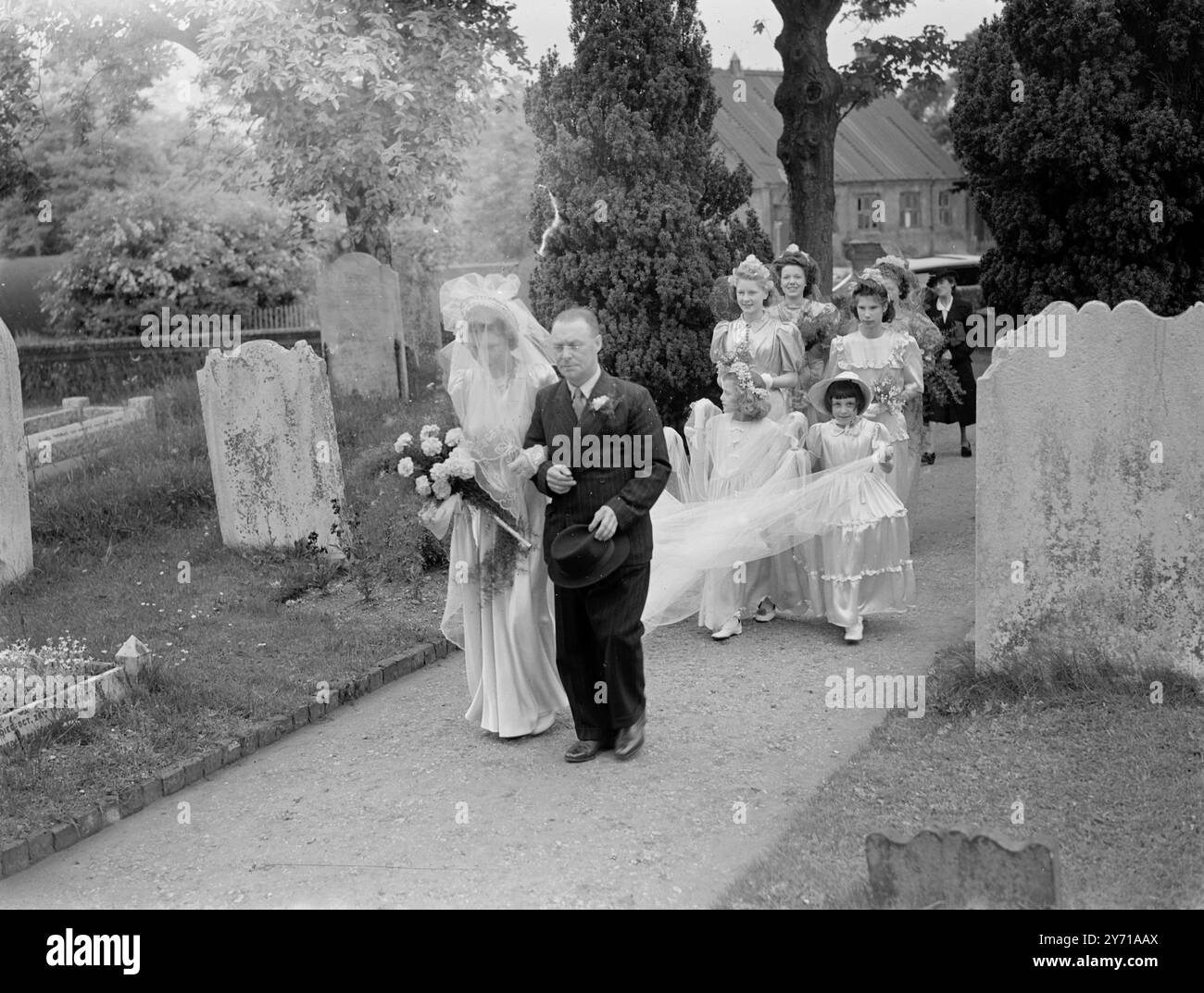 Matrimonio - Manley - Millner. La damigella d'onore di Crayford trasporta il treno delle spose 1940 Foto Stock