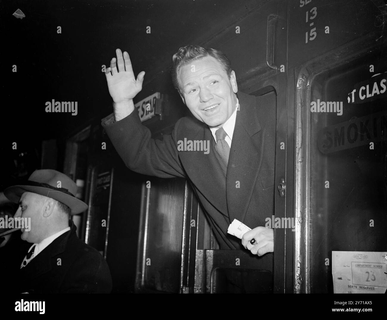 LEE SAVOLD TORNA A CASA - TORNERÀ A COMBATTERE DI NUOVO il peso pesante americano - LEE SAVOLD , che è stato squalificato per un duro colpo nella sua lotta contro Bruce Woodcock , ha lasciato Waterloo Station , Londra con il treno per il Canard White Star liner '' Queen Mary'' in viaggio verso l'America . Si aspetta di tornare in Gran Bretagna entro metà estate per combattere il vincitore del campionato dei pesi massimi Bruce Woodcock - Freddie Mills a giugno . Savold ha promesso di tornare, indipendentemente dal fatto che combatta o meno con Joe Louis. IMMAGINI MOSTRANO :- LEE SAVOLD salutando addio mentre lascia Waterloo sta Foto Stock