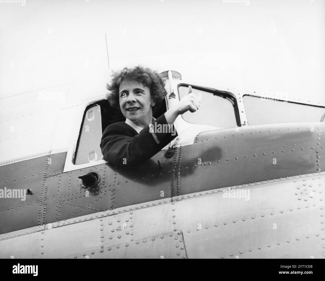 Dando il pollice in su il cartello dal cockpit di un aereo è vedova di 34 anni e madre di due figli, la signora Yvonne Pope , che diventerà la prima donna pilota britannica a volare per una grande compagnia aerea quando farà la sua prima corsa oggi su un volo merci di linea per Dusseldorf in Dakota Aircraft della Morton Air Services . Yvonne, ex controllore del traffico del Ministero dell' aviazione all' aeroporto di Gatwick, ha iniziato come hostess , ha lavorato per le compagnie aeree nazionali e si è addestrata a volare al club di volo della British European Airways , dove ha incontrato il suo defunto marito , che era un pilota charter . Foto Stock