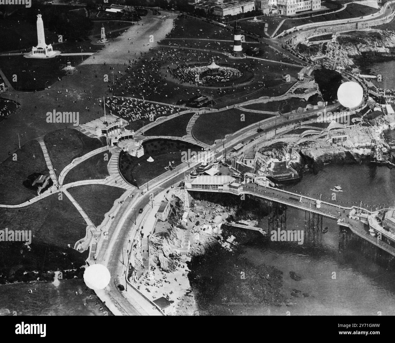 Plymouth Corporation ha avviato i lavori di miglioramento del lungomare. Sono iniziati ieri ulteriori miglioramenti al litorale, ampliamenti alle numerose piscine e bagni, l'ampliamento della strada di fronte al famoso Plymouth Hoe (dove Drake giocava le bocce). Sono in corso spese 60.000 sterline per questi miglioramenti e ogni anno verranno apportate ulteriori modifiche e verrà costruito un padiglione aggiornato. Spettacoli fotografici: Veduta aerea della Plymouth Hoe e del litorale. La Marine Drive segnata da punti deve essere estesa a 60 piedi e la passeggiata del colonnato è prevista. Il famoso Smeaton Tower Naval War Memorial Foto Stock