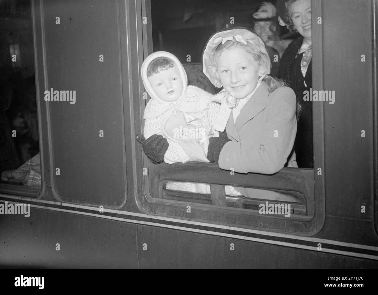 NUOVE VITE PER UNDICI CENTINAIA la SS ORMONDE salpa da Tilbury per l'Australia portando oggi 1100 uomini, donne e bambini britannici a nuove vite ' Down Under' Boat -i treni da St. Pancras erano occupati questa mattina portandoli giù alla nave all emigrante . IMMAGINI:- V.I.P. sulla barca-treno per Tilbury da St. Pancras questa mattina c'era una bambola fuori misura della bambina di otto anni BETTY MILNE di Liverpool , che è diretta a Bathurst , N.S.W. qui dicono addio dalla finestra della carrozza. 21 maggio 1948 Foto Stock