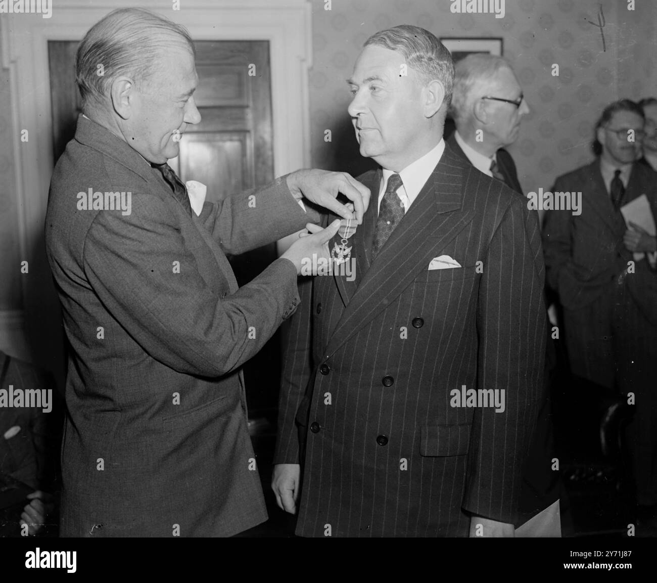MEDAGLIA AL MERITO DEGLI STATI UNITI PER IL CAPO DELLA CENSURA. Un premio della United States Medal for Merit, è stato conferito oggi dall'ambasciatore statunitense LEWIS W. DOUGLAS, al 1.Grosvenor Square, Londra, a SIR EDWIN HERBERT, per "condotta eccezionalmente meritoria....per la sicurezza degli Stati Uniti e dei suoi alleati, durante la guerra contro l'asse..." . Come direttore generale della censura delle poste e del telegrafo britannico, SIR EDWIN organizzò e ' prese la leadership nella ...prima censura mondiale efficace nella storia' MOSTRA:- il signor LEWIS DOUGLAS incolla la medaglia al merito su SIR EDWIN HERBERT a G. Foto Stock