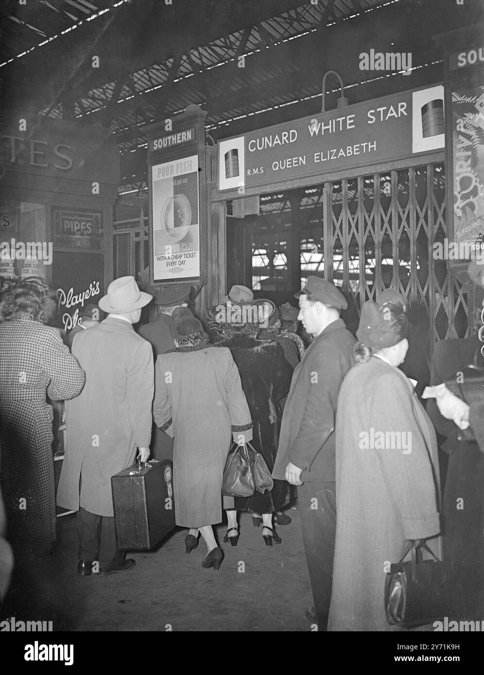 LA REGINA ELISABETTA SALPERÀ DOMANI la nave di linea Cunard White Star Queen Elizabeth la cui data di navigazione è stata ritardata dallo sciopero dei New York Longshoremen salperà da Southampton . La nave doveva essere consegnata a New York lunedì scorso e avrebbe dovuto ripartire mercoledì . I passeggeri per il viaggio lasciarono Londra con i treni Queen Elizabeth per Southampton. IMMAGINI:- passeggeri per i treni Queen Elizabeth alla stazione di Waterloo, passando attraverso l'entrata della piattaforma , vedi il familiare avviso Queen Elizabeth . 19 novembre 1948 Foto Stock