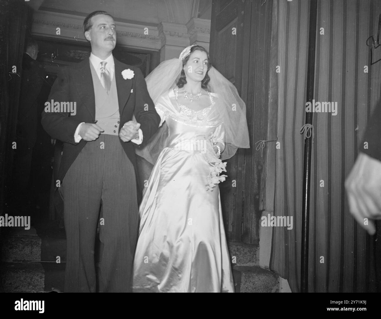 LE PERLE E IL MATRIMONIO DI CRISTALLO PER EREDE- DAMIGELLE D'ONORE IN ROSSO l'EREDITIERA Miss Ruadh Daphne Watson , nipote del defunto Sir Charles Jackson , era sposata con l'On . FRANCESCO LEGH, figlio di Lord Newton, a St. George's Church , Hanover Square , Londra. La sposa indossava un abito da sposa in vita da 18 pollici '' Tube-look'' di Lorian , ricamato in perle e cristalli di semi , con un treno da 10 iarde . Il suo berretto Juliet era a mano incarnato in un motivo di gocce di cristallo e perle opalescenti. Il nome Ruadh è gaelico per il rosso, la damigella d'onore indossava tutto il rosso e il velluto. Lo zio della sposa, Oxford Don An Foto Stock