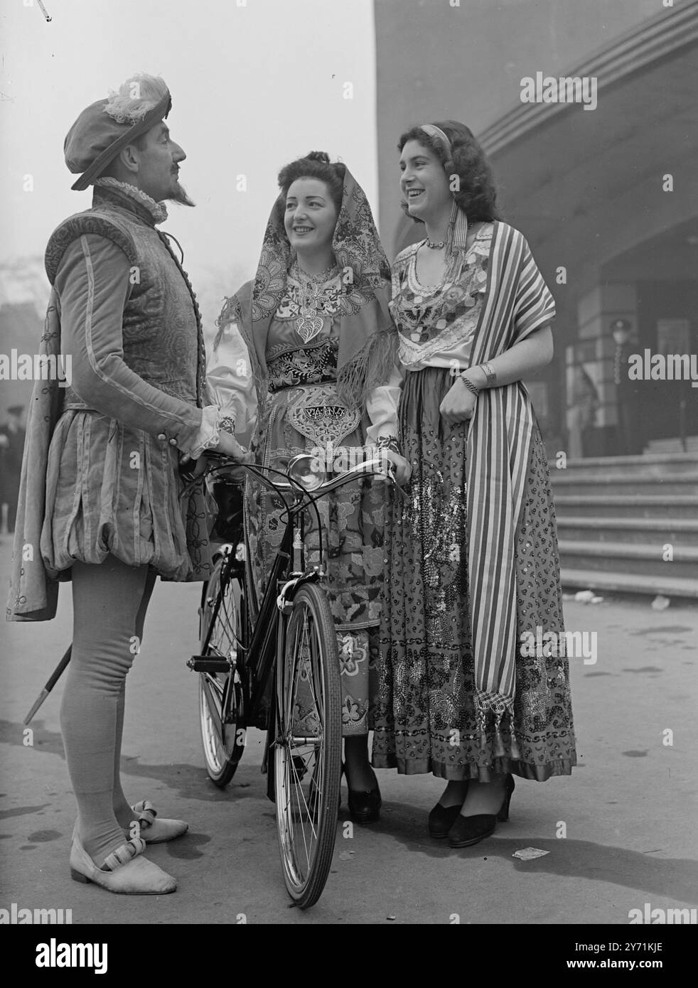 Una caratteristica interessante di una parata di Cycle Show tenuta dalla Raleigh Industries alla Seymour Hall di Londra sarà la rappresentazione di quattordici ragazze di Nottingham di alcuni dei paesi verso i quali la società di cicli sta esportando. Vestite con costumi nazionali, tutte autentiche, ottenute dai loro paesi d'origine, le ragazze rappresenteranno Argentina, Belgio, Cina, Danimarca, Eire, India , Malesia , Svezia, Svizzera e Turchia . - - - - LA FOTO MOSTRA:-' Sir Walter Raleigh, rappresentato dal signor. H.F. Smith , ha qualche parola con la signorina . RITA TULLY (a sinistra) , in costumi portoghesi , e IRIS JICKLIN Foto Stock