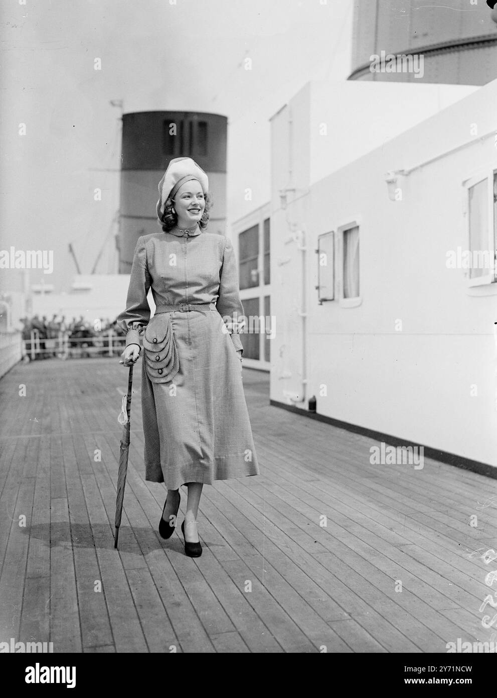 LA STAR AMERICANA DEL CINEMA TORNA negli Stati Uniti tra i passeggeri della Cunard White Star Liner ' REGINA ELISABETTA ' che salpò da Southampton a New York , c'era Miss ELEANOR PARKER , star del cinema americano . L' IMMAGINE MOSTRA :- ' STAR A BORDO ' che sembra gay e si veste in un abito dal collo alto di nuovo aspetto con un elegante effetto tascabile e un cappello a tesa alta , è Miss . ELEANOR PARKER che sta tornando negli Stati Uniti sulla REGINA ELISABETTA . 9 giugno 1948 Foto Stock