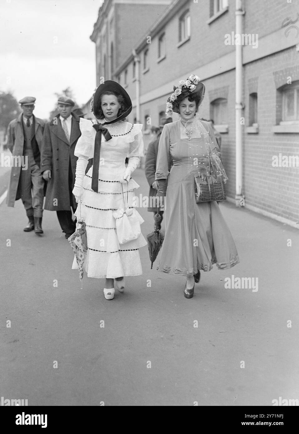Accento su Ascot. Vestiti alla moda per la riunione del terzo giorno di Royal Ascot, questi due amanti della corsa mostrano un contrasto nel costume. La signora a sinistra preferisce un cappello da foto con nastro allacciato, per completare il suo abito bianco in stile crinoline, mentre la sua compagna usa rose e velature per accompagnare il suo abito da balletto, oggi (giovedì). 17 giugno 1948 Foto Stock