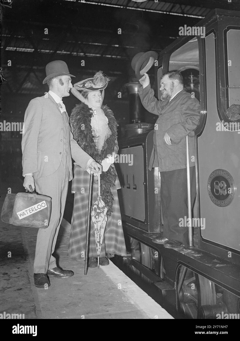 "TORNANDO INDIETRO L'OROLOGIO A WATERLOO" i passeggeri della stazione di Waterloo, Londra, assistettero ad uno spettacolo insensato a metà giornata, quando un motore e un pullman del 1903 entrarono al binario 15 e videro un uomo e delle donne scendere vestiti con costumi all'inizio del XIX secolo. Questo faceva parte dei festeggiamenti per il centenario di Waterloo , che comprendeva anche una mostra di immagini e reliquie che mostravano i primi anni di vita della stazione . In quei giorni la stazione aveva quattro piattaforme , ora ne ha 21 e copre 24 acri e mezzo . L'IMMAGINE MOSTRA :- " legato per 1800 " il pilota Braerded PERCY COX saluta IL SIGNOR e SIMONS e. Foto Stock