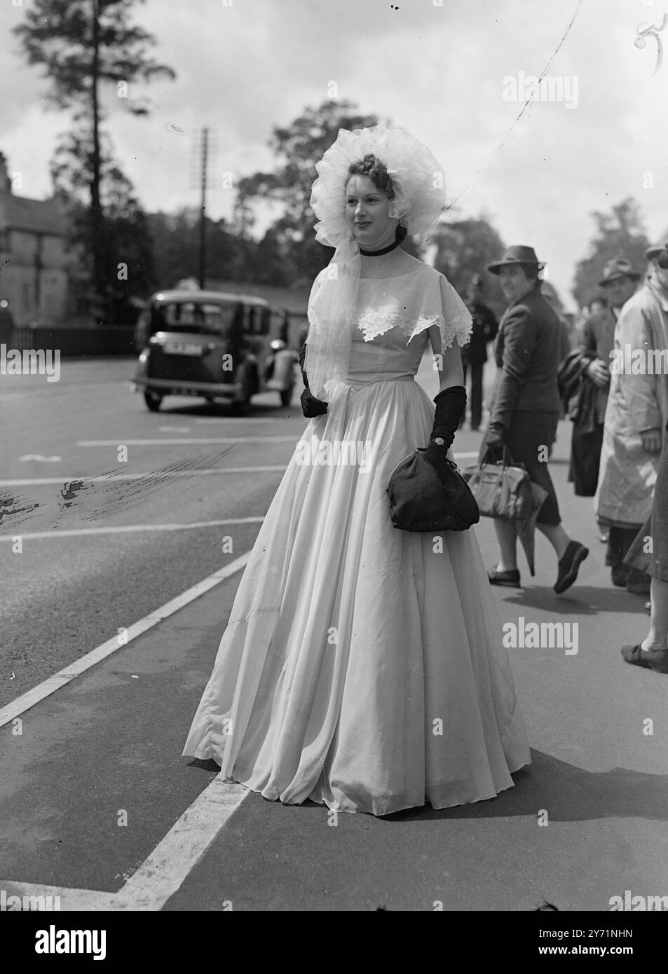 Royal Ascot. Riunione dell'ultimo giorno. Le loro Maestie il Re e la Regina, oggi (venerdì), hanno partecipato alle riunioni del quarto giorno della Royal Ascot, dove, nonostante il tempo incerto, il solito mucchio di nuove mode ha fatto la loro comparsa. L'immagine mostra: "Abiti per bambini" - indossa un cappello completo con il cappuccio e la sua creatura a tutta lunghezza, con la gonna larga, Miss E.. Shelley aggiunge guanti neri e borsa per un contrasto intenso ad Ascot Today (venerdì). 18 giugno 1948 Foto Stock