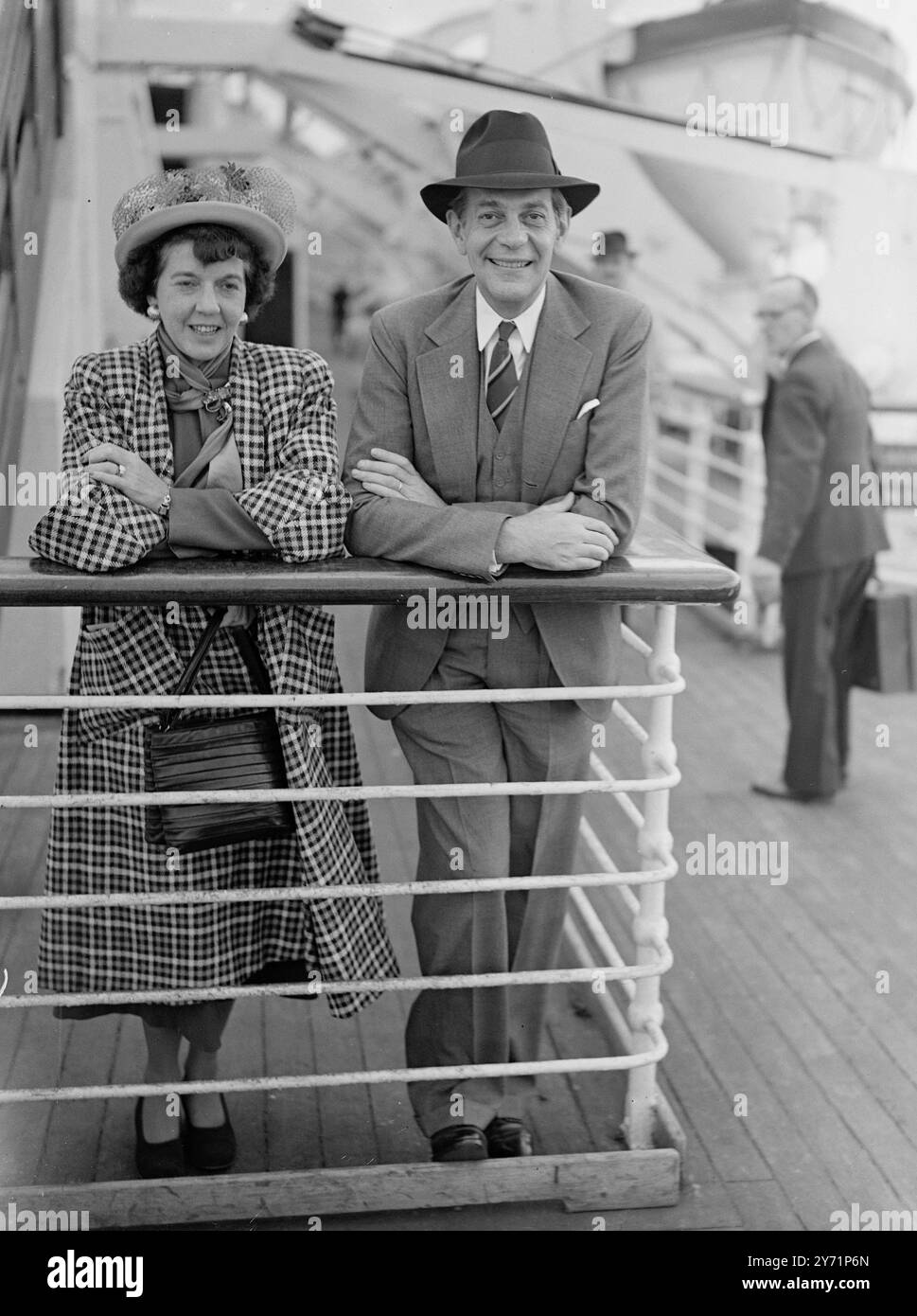 A bordo della Cunard White Star Liner Queen Elizabeth, ormeggiata oggi a Southampton, era la star del cinema Raymond Massey, che è qui per interpretare il BEST seller di Stuart Cloete, Turning Wheels. L'immagine mostra: 'Happy to Be Here' - la star del cinema Raymond Massey, nella foto con la moglie, all'arrivo a Southampton oggi. Foto Stock