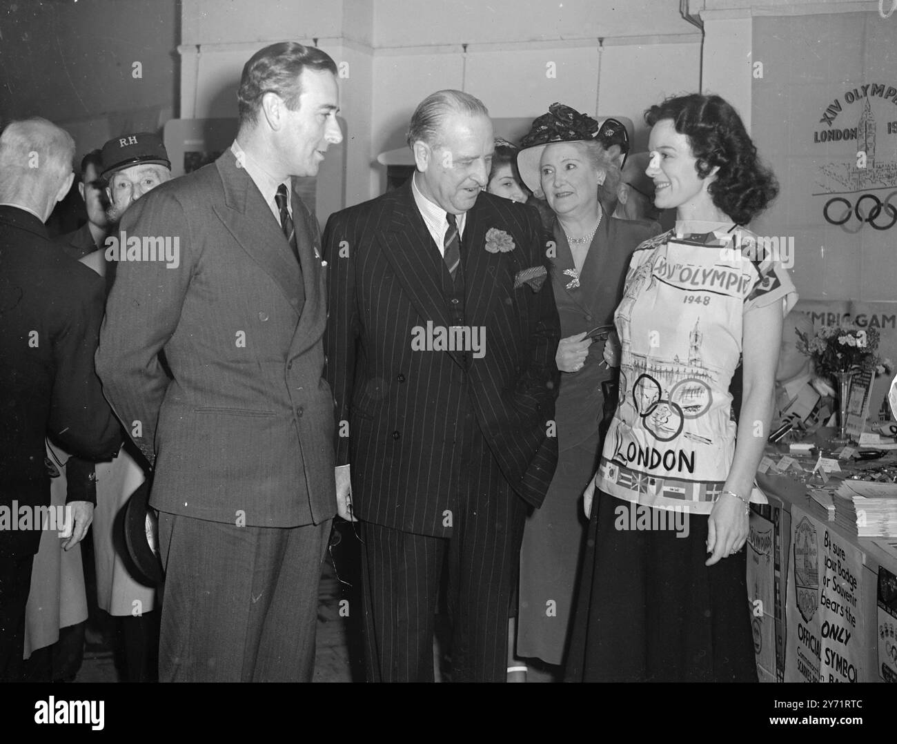 Earl Mountbatten partecipa allo Sportsmen's Show presidente della National Playing Fields Association , presieduto in anteprima alla Sportsmen's Exhibition presso l'Academy Exhibition Hall , Oxford Street , Londra . Molte star dello sport britannico saranno alla fiera durante la sua corsa . Immagini : primo piano olimpico - il visconte Mountbatten guarda la camicetta olimpica ufficiale indossabile come sciarpa , indossata dalla signorina Brene Brunt in anteprima alla Mostra degli sportivi . Sir Noel Curtis Bennet è presidente della Playing Fields Association . 9 luglio 1 Foto Stock