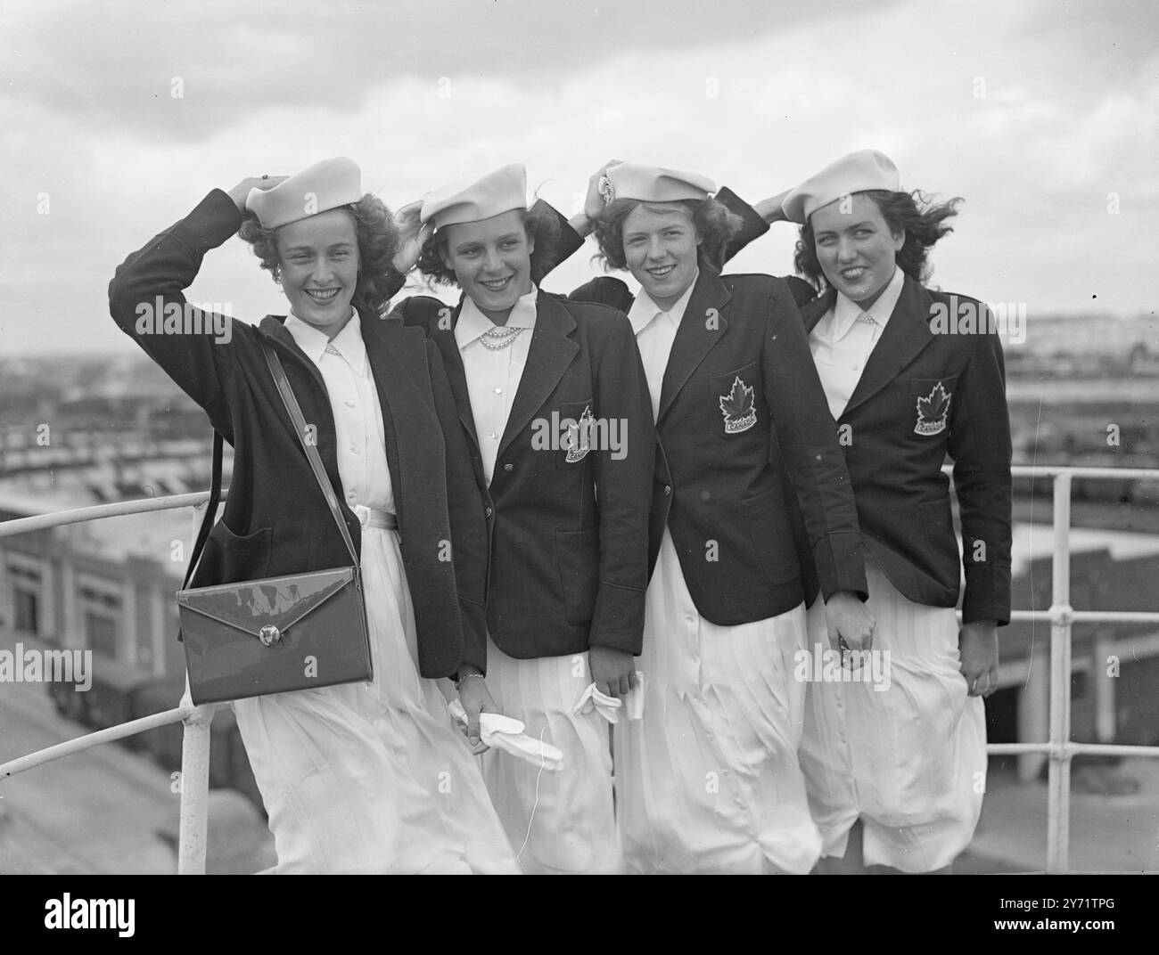 "Maple Leafs Blow in" - le ragazze olimpiche canadesi arrivano dal Canada a bordo della Cunard White Star Liner "Aquitania", a Southampton, questi membri della squadra olimpica canadese, hanno trovato il tempo piuttosto ventilato. Da sinistra a destra - donna Gilmore, di Vancouver; Kay McNamee, di Vancouver; Doreen Dredge, di Saskatoon; e Irene strong di Vancouver. 22 luglio 1948 Foto Stock