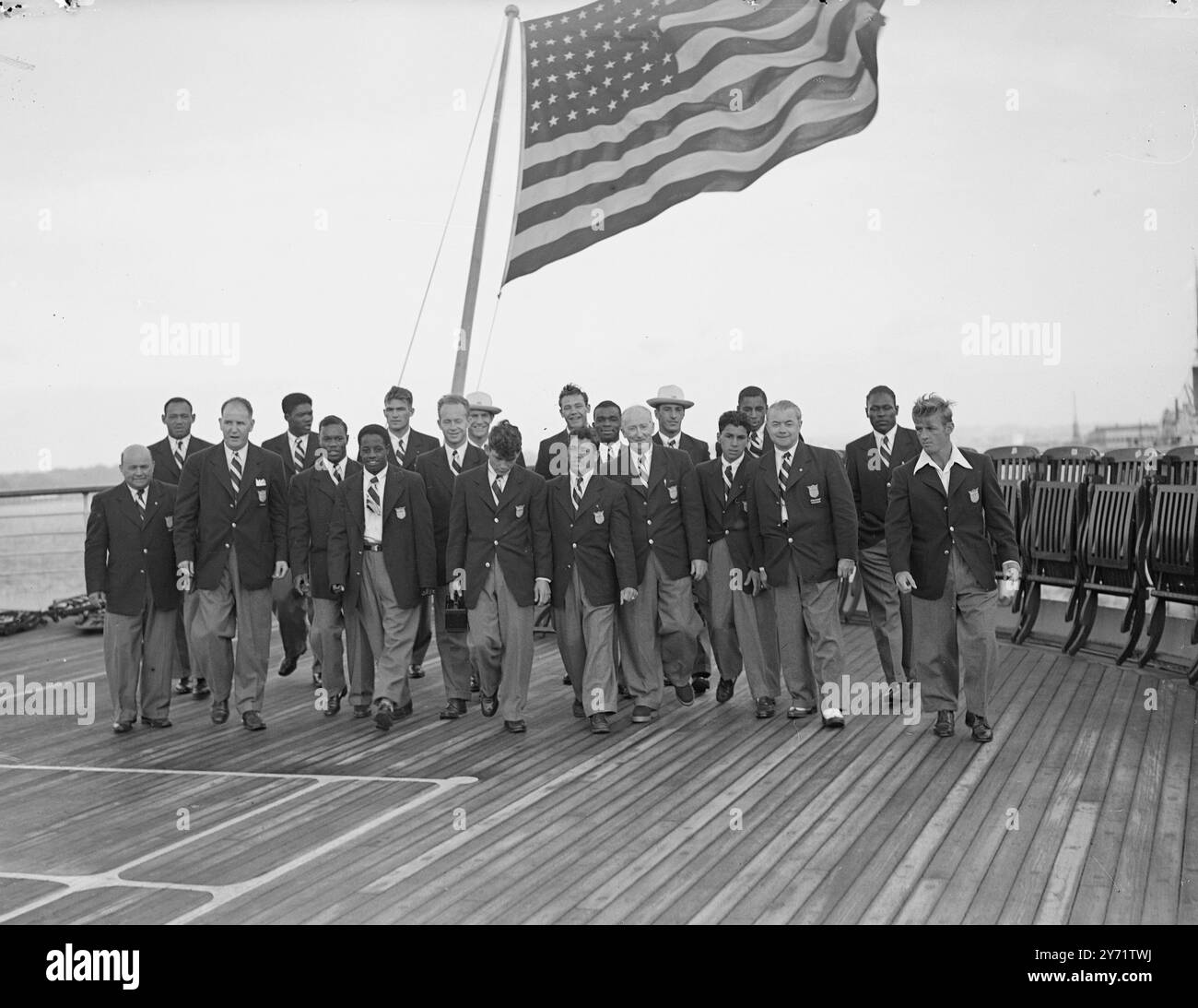 "Sotto la loro bandiera” - la squadra olimpica statunitense qui i membri della squadra olimpica americana camminano sul ponte della SS "America”, che attraccò a Southampton, sotto la bandiera degli Stati Uniti. 21 luglio 1948 Foto Stock
