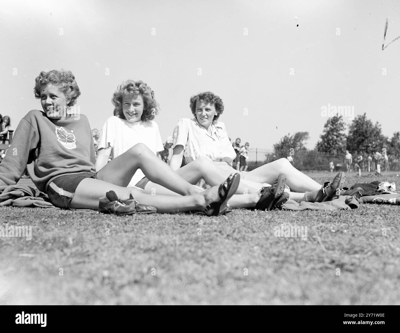 "Riposati" queste tre atlete olimpiche si riposano tra una faticosa pratica al Southall Recreation Ground, dove si allenano per i Giochi che iniziano giovedì prossimo. Tutti dal Canada, sono (da sinistra a destra), Dianne Foster, Vancouver; donna Gillmore, Vancouver; e Nancy MacKay, di Toronto. 26 luglio 1948 Foto Stock