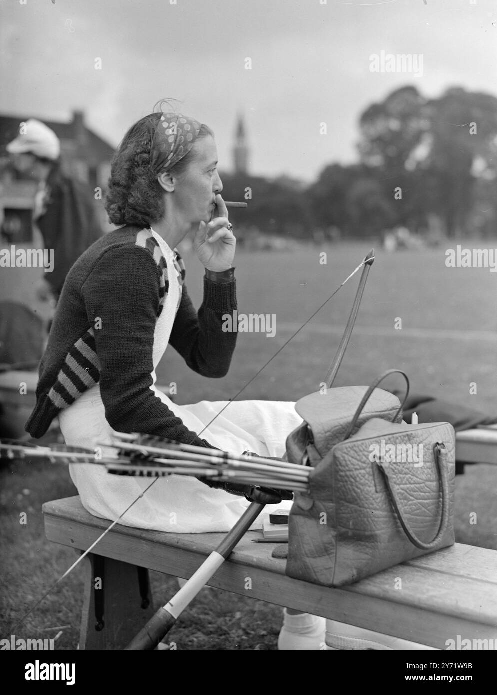 Un sigaro mentre aspetta - Torneo di tiro con l'arco. Metza Jorgensen, dalla Danimarca, prende un bel boccone al suo sigaro mentre attende il suo turno per sparare nel dodicesimo Torneo Internazionale di tiro con l'arco che si sta svolgendo a Dulwich Grounds. 10 agosto 1948 Foto Stock