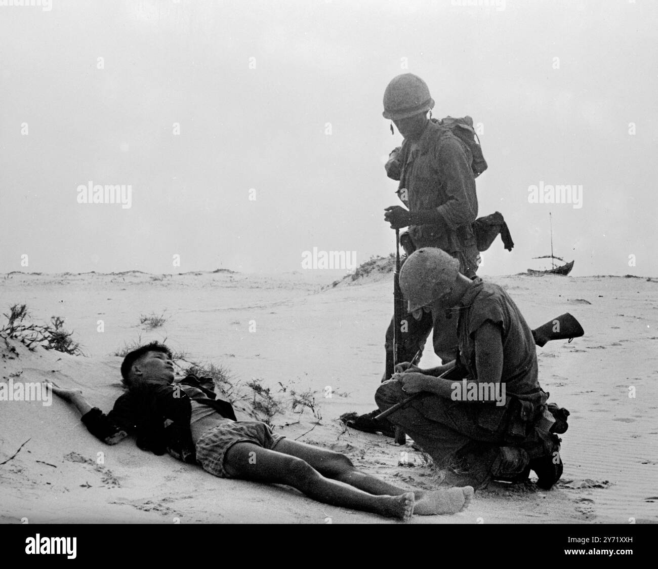 Nome, rango e numero di serie... Chu Lai, Vietnam del Sud : su un tratto sabbioso vicino alla base aerea di Chu Lai, due dei marines statunitensi cercano informazioni da un sospetto Viet Cong ferito che è stato catturato nel luglio 25 1965, quando i manicotti di pelle e le truppe sudvietnamite hanno fatto irruzione in un villaggio vicino alla ricerca dei guerriglieri comunisti. I terroristi di Viet Cong raramente vengono beccati con le uniformi. 20 gennaio 1967 Foto Stock