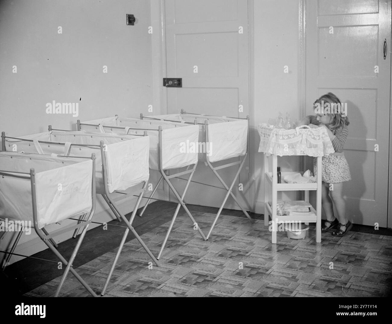 PREPARAZIONE FINALE PER LA CUCINA CASALINGA "QUADRUPLA". I Bristol Quads, Elizabeth, Jennifer, Bridgett e Francis, di undici settimane, tornano a casa nella nuova casa gemella dei loro genitori, il signor e la signora, Good, del Quadrangle, Westerleigh, (Glos) mercoledì e ogni cosa è stata preparata per il loro ricevimento, comprese quattro nuovissime culle, con i nomi incisi, che si vedono nella foto. Susan Good di due anni e mezzo insiste nel fare la sua parte e dà una mano con i biberon. 13 settembre 1948 Foto Stock PREPARAZIONE FINALE PER LA CUCINA CASALINGA "QUADRUPLA". I Bristol Quads, Elizabeth, Jennifer, Bridgett e Francis, di undici settimane, tornano a casa nella nuova casa gemella dei loro genitori, il signor e la signora, Good, del Quadrangle, Westerleigh, (Glos) mercoledì e ogni cosa è stata preparata per il loro ricevimento, comprese quattro nuovissime culle, con i nomi incisi, che si vedono nella foto. Susan Good di due anni e mezzo insiste nel fare la sua parte e dà una mano con i biberon. 13 settembre 1948 Foto Stock