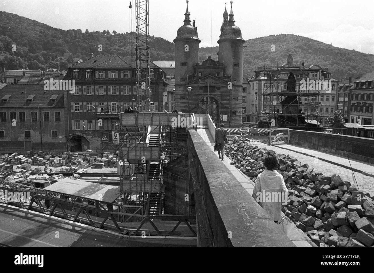 Heidelberg, Germania: Pedoni che attraversano il "vecchio ponte" sul fiume Neckar nella città universitaria tedesca di Heidelberg. Il ponte , costruito nel 1786-1788 , è attualmente in fase di smantellamento per consentire l' ampliamento di un' autostrada fluviale . Durante lo smantellamento , ogni sezione in pietra viene numerata per consentire il rimontaggio del ponte vecchio di 180 anni al termine dei lavori stradali . 30 giugno 1969 Foto Stock