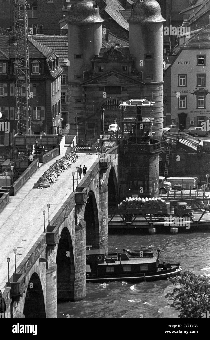Heidelberg, Germania: Pedoni che attraversano il "vecchio ponte" sul fiume Neckar nella città universitaria tedesca di Heidelberg. Il ponte , costruito nel 1786-1788 , è attualmente in fase di smantellamento per consentire l' ampliamento di un' autostrada fluviale . Durante lo smantellamento , ogni sezione in pietra viene numerata per consentire il rimontaggio del ponte vecchio di 180 anni al termine dei lavori stradali . 30 giugno 1969 Foto Stock