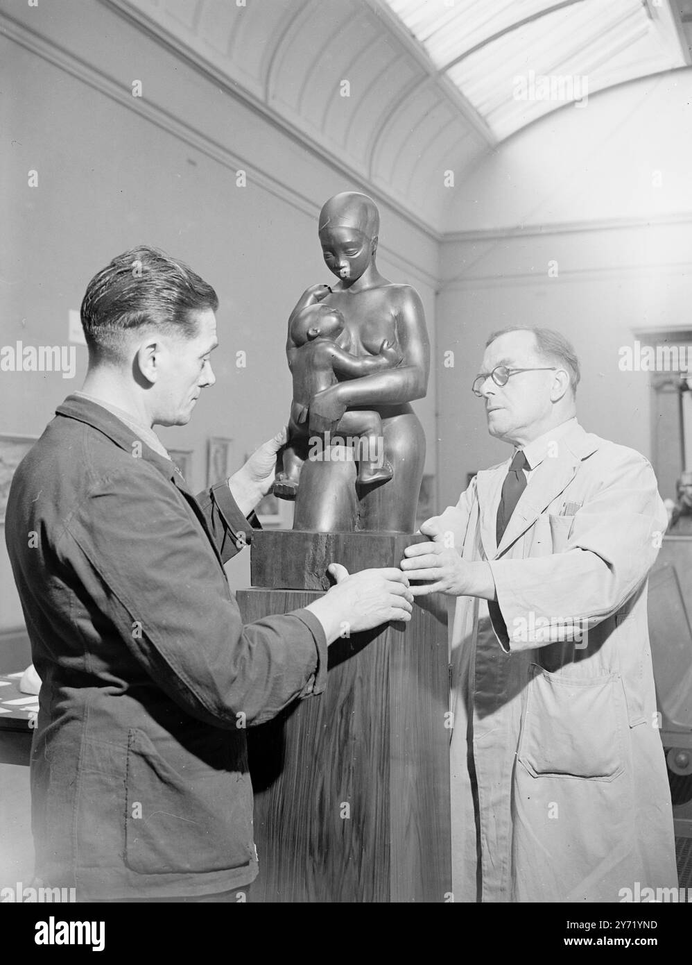 ART FROM SOUTH AFRICA presso la Tate Gallery è stata inaugurata una mostra di arte sudafricana organizzata dalla South African Association of Arts con il sostegno del governo dell'Unione. Leif Egeland , alto Commissario per il Sudafrica . Ci sono circa 140 dipinti ed esempi di scultura nella mostra . Due assistenti della Tate Gallery spostano una delle mostre - "madre e bambino" in posizione prima dell'apertura. Moses Kottler è l'autore di questo lavoro , realizzato in legno . 20 settembre 1948 Foto Stock