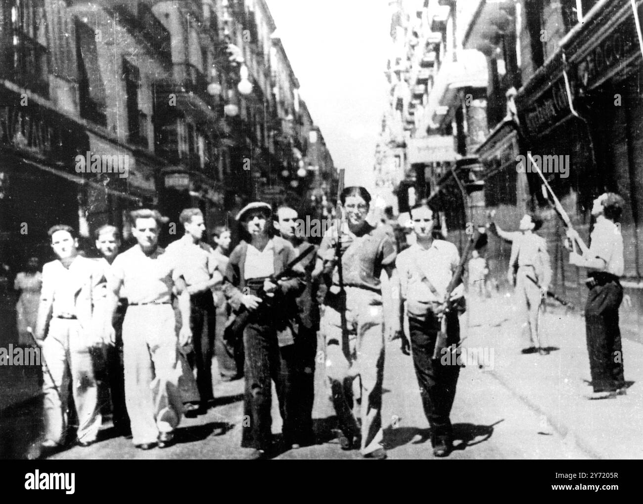 BARCELLONA CENTRO DEI COMBATTIMENTI PIÙ PESANTI DELLA GUERRA CIVILE - 8.000 MORTI . Queste foto , provenienti da Barcellona , centro dei combattimenti più pesanti della guerra civile spagnola , furono inviate via aerea a Marsiglia e telefoto a Londra . Le numerose battaglie di strada e i bombardamenti hanno provocato la morte di ottomila persone . Il governo ora sostiene di avere il controllo sulla città. IMMAGINI:- uomini armati che pattugliano le strade di Barcellona . 23 luglio 1936 Foto Stock