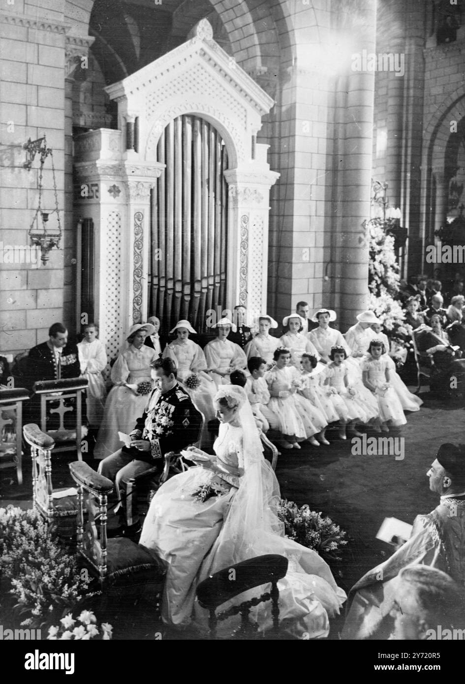 Ranieri e Grazia in un momento solenne Monaco : il Principe Ranieri III e la sua sposa Grace Kelly, siedono solennemente nella Cattedrale di San Nicola durante la loro cerimonia religiosa del matrimonio, condotta dal Vescovo Gilles Barthe. Il Principe indossa un'uniforme decorata con molti ordini e decorazioni. La coppia reale sarà in luna di miele nel Mediterraneo a bordo del Royal Yacht. Foto Stock