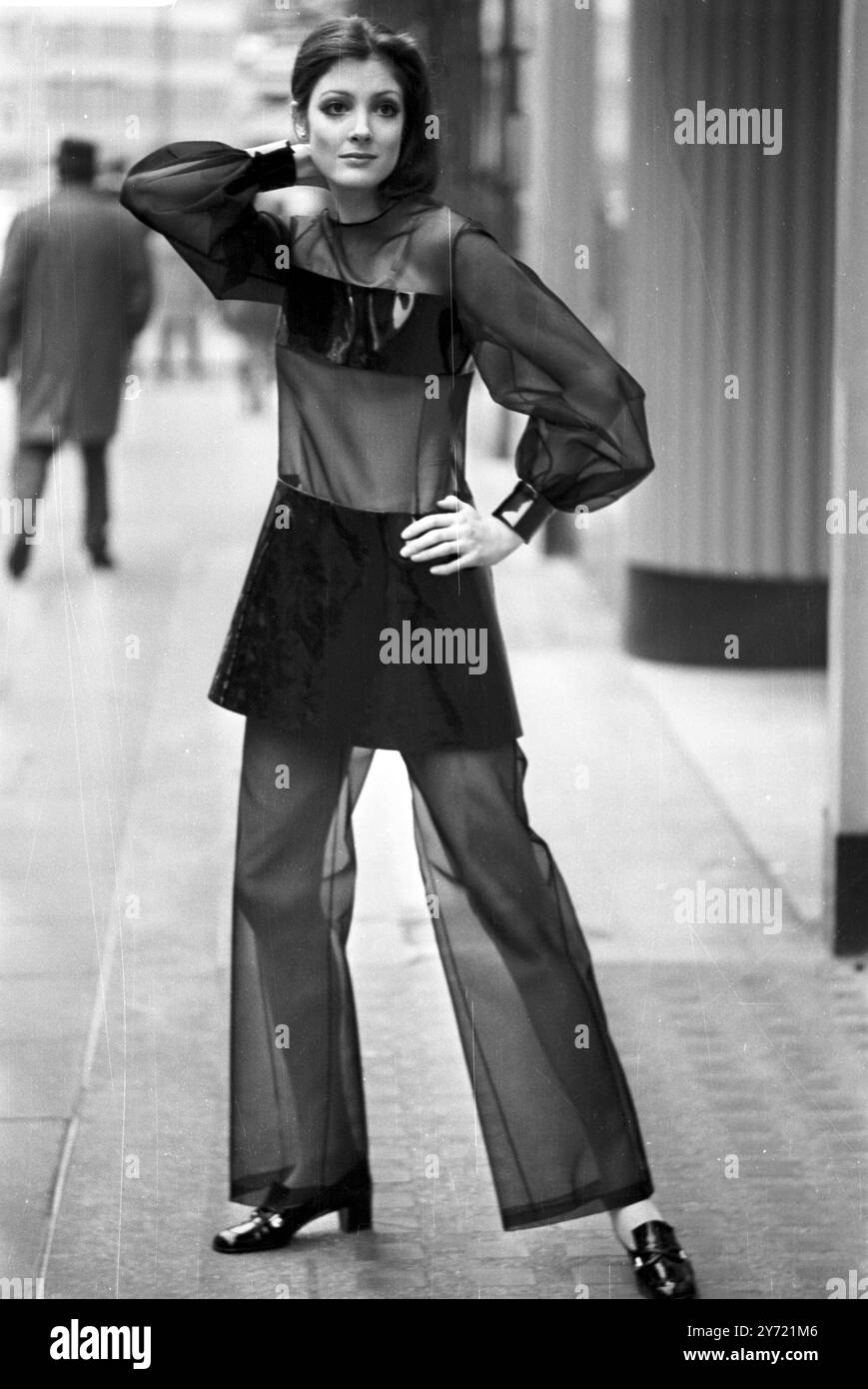 Questa intrigante combinazione tunica / pantaloni in organza nera e vinile , indossata da Clare Ferson , è stata vista nella collezione Christian Dior - London Spring '69 , degnata da Jorn Langberg e presentata alla stampa a Londra . 4 marzo 1969 Foto Stock