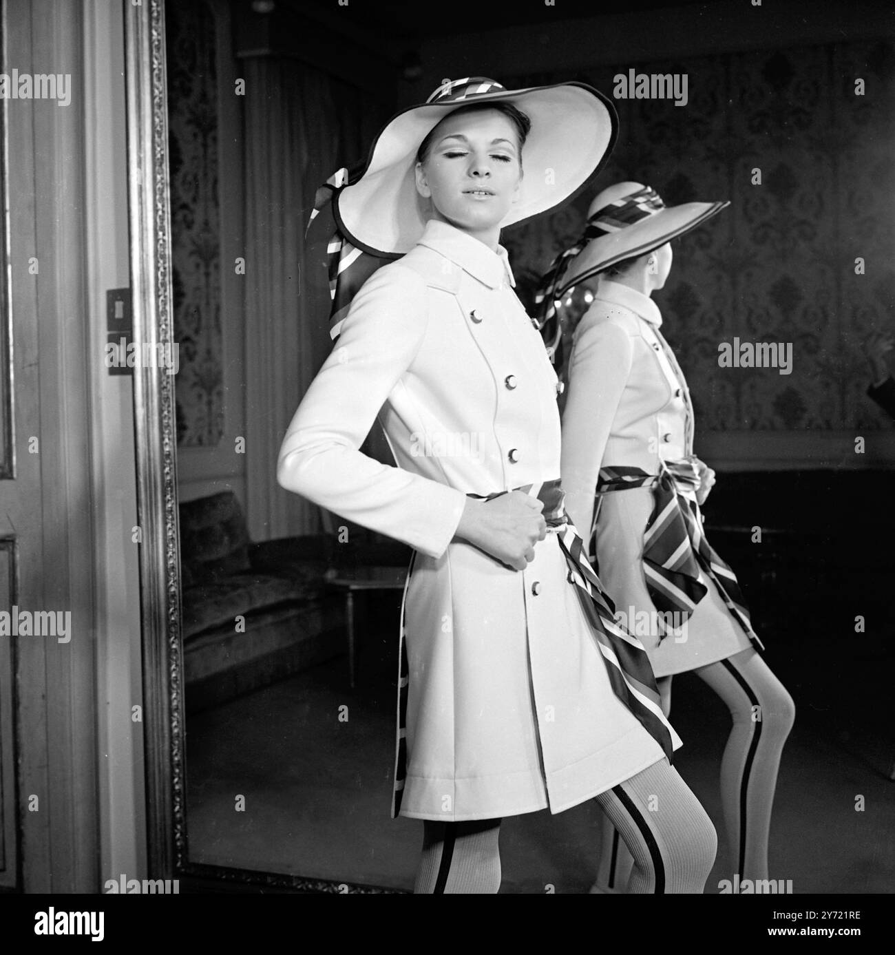 Tiziani Designs The House of Tiziani ha tenuto la sua anteprima di moda primavera ed estate il 10 gennaio 1968. Il look con cintura è una caratteristica di spicco della collezione, come qui mostrato in un abito e cappello di lana bianca con sciarpe rosse, bianche e blu abbinate per una cintura e un accessorio cappello Roma , Italia Foto Stock
