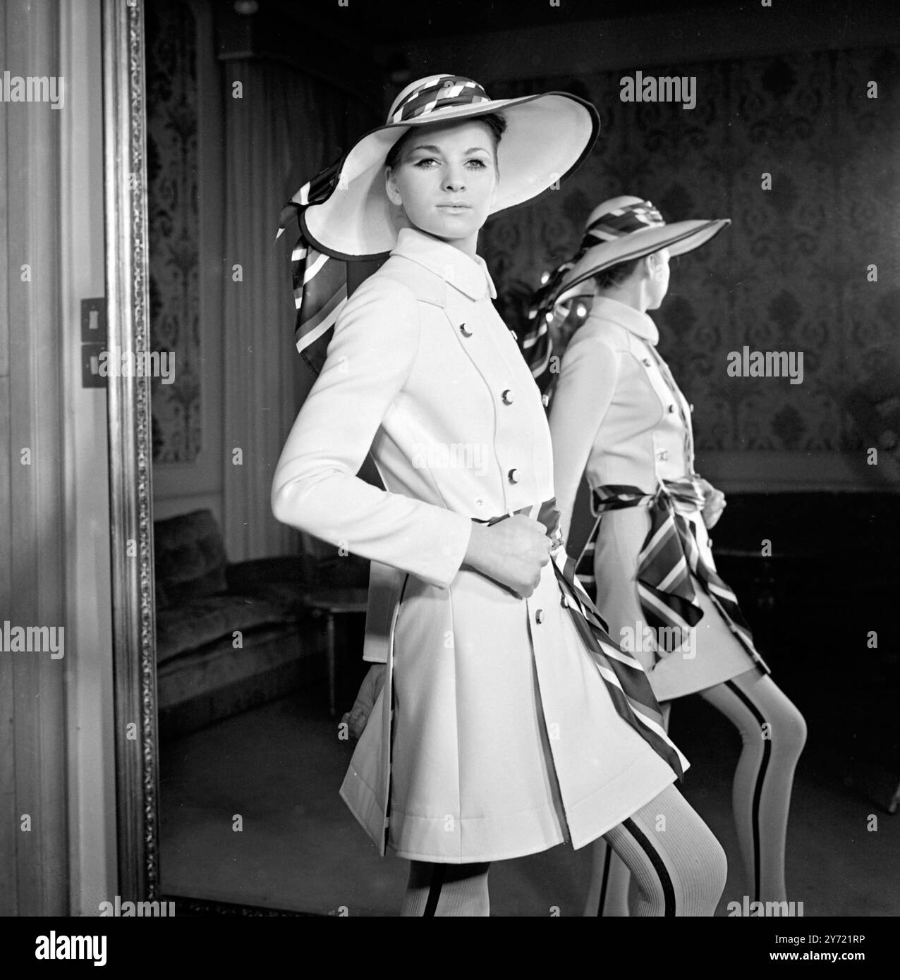 Tiziani Designs The House of Tiziani ha tenuto la sua anteprima di moda primavera ed estate il 10 gennaio 1968. Il look con cintura è una caratteristica di spicco della collezione, come qui mostrato in un abito e cappello di lana bianca con sciarpe rosse, bianche e blu abbinate per una cintura e un accessorio cappello Roma , Italia Foto Stock
