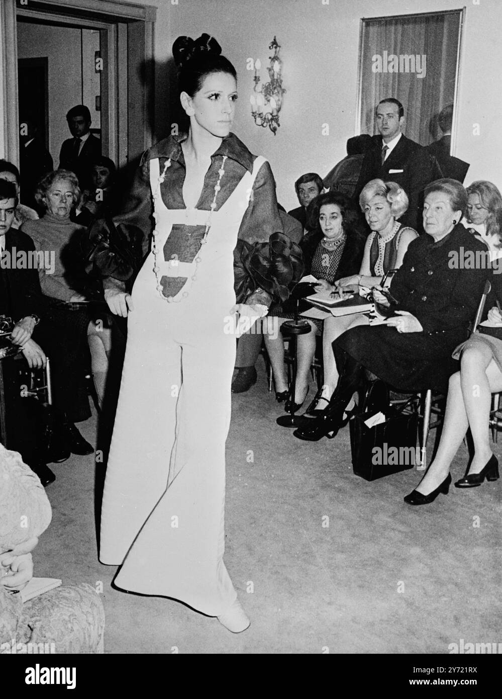 Tiziani disegna fiori giganti rossi e blu decorano il polsino di una camicia organza rossa indossata sotto una tuta in bianco con righe bianche intrecciate - un outfit della collezione Primavera-Estate di EvanTiziani 25 gennaio 1969 a Roma Foto Stock