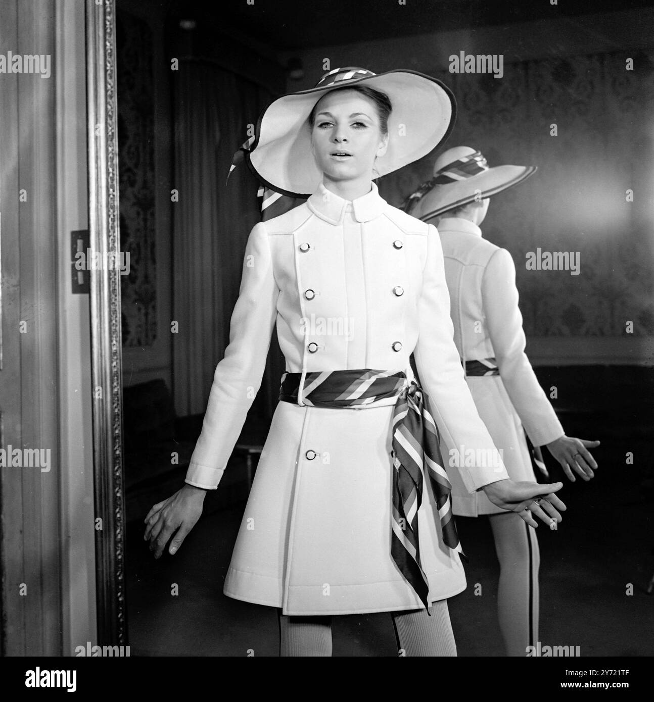 Tiziani Designs The House of Tiziani ha tenuto la sua anteprima di moda primavera ed estate il 10 gennaio 1968. Il look con cintura è una caratteristica di spicco della collezione, come qui mostrato in un abito e cappello di lana bianca con sciarpe rosse, bianche e blu abbinate per una cintura e un accessorio cappello Roma , Italia Foto Stock