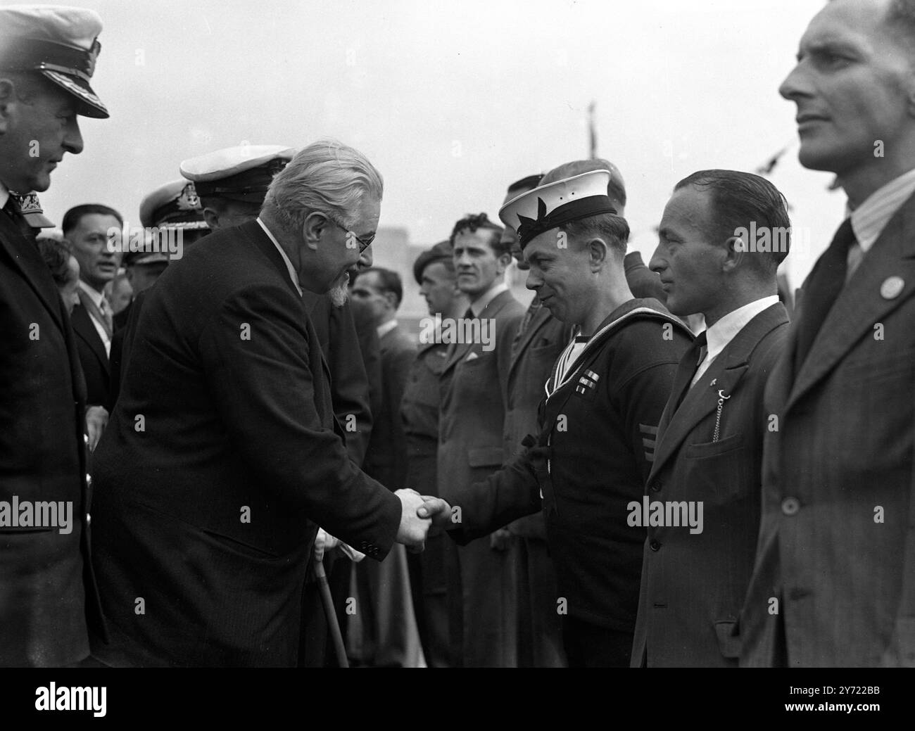 Questa mattina presto l' incrociatore Sirius salpò la Loira verso St Nazaire , Francia , riportando i sopravvissuti sulla scena del loro epico raid , per onorare i loro compagni perduti . Essi furono accolti in modo commovente dal popolo della città mentre marciavano a riva con la targa di bronzo , recanti la scritta "hanno realizzato molto, avendo osato tutto", per i francesi preparavano il monolito. M Ramadier , il Premier francese , stringe la mano a Seaman Hutchins della HMS Sirius , congratulandosi con lui per il lavoro svolto durante il raid . Seaman Hutchins ha impostato l'ultima miccia di carica di profondità nel cacciatorpediniere Campbeltown utilizzato per far esplodere Foto Stock