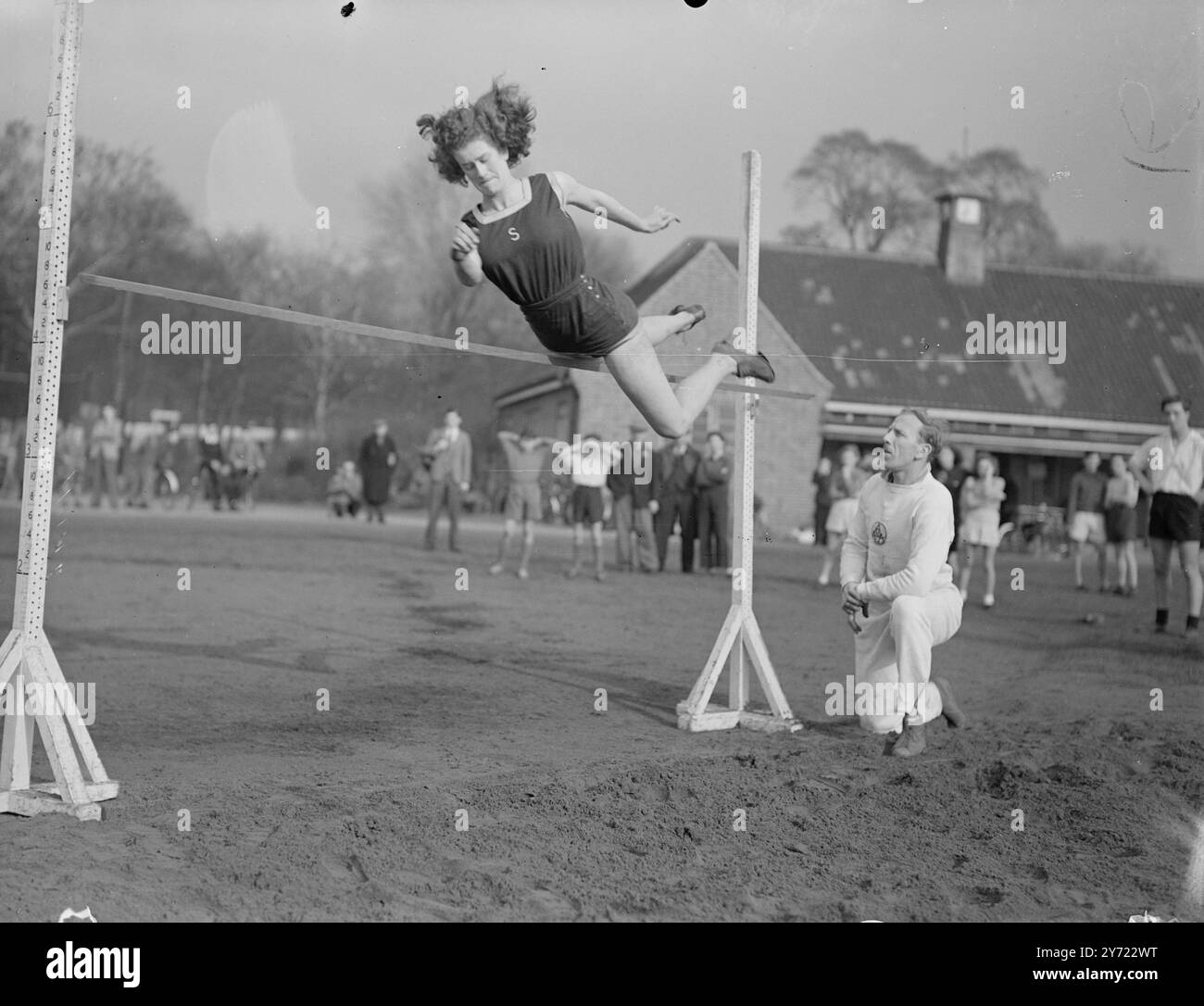 Azione Amazon. La donna sull'ala è Sheila Alexander, campione del Surrey e del L.C.C., che fa questo studio di preoccupazione mentre si allena per l'inclusione nella squadra olimpica britannica, sotto gli occhi di G.J.Pallett, l'A.A.A. Coach, al Tooting Bec Athletic Ground. La High Jumper Sheila è arrivata in tutti i campionati inglesi. 20 febbraio 1948. Foto Stock