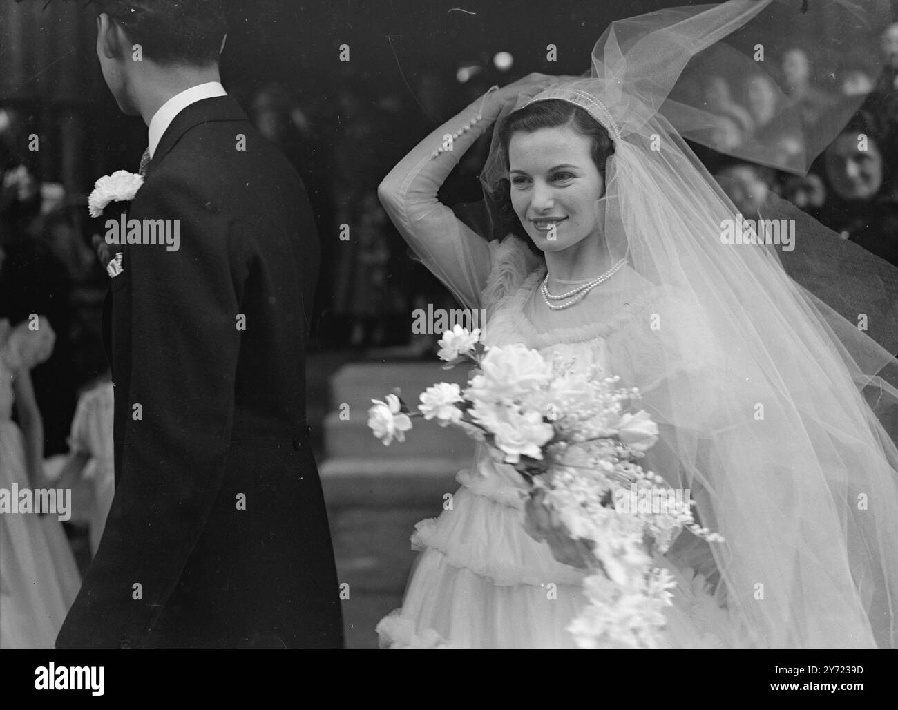 Sir Albert Cahn Weds Miss Malka Bluestone. - - Il matrimonio di Sir Albert J. Cahn BT e Miss Malka Bluestone si sono svolte oggi presso la sinagoga del New West End, Bayswater. Figlio del defunto Sir Julien Chan tenente sportivo e filatropo, Sir Albert ha 24 anni, ha prestato servizio nel R.E.M.E. durante la guerra. - La foto mostra: "Sposa al vento" - il vento di marcia scortese gioca trucchi con il velo del classico abito da sposa della sposa, dopo la cerimonia, oggi (martedì). - - - 16 marzo 1948. Foto Stock