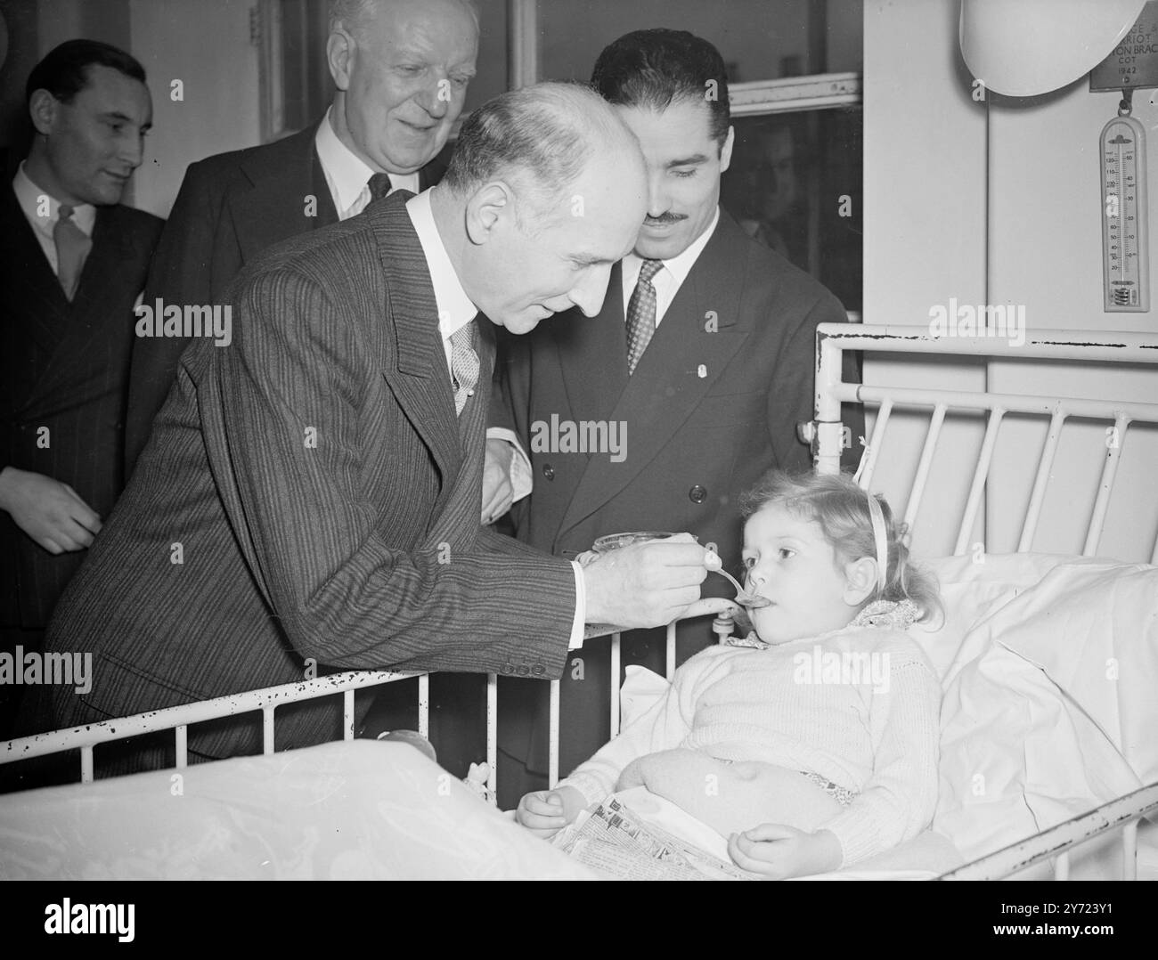 Miele argentino per bambini malati. Sua Eccellenza il senatore Don Ricardo de Labougle, Ambasciatore argentino a Londra, era presente in occasione della distribuzione di 138 sterline di miele all'ospedale per bambini malati St Ormond Street, oggi (giovedì). Presentata dalla Repubblica argentina alla Croce Rossa britannica per la distribuzione a 36 ospedali e case per bambini convalescenti in tutto il paese, la spedizione totale ammonta a 42 casi. Spettacoli fotografici: Janet Wollgar di quattro anni e mezzo riceve un assaggio di miele da parte di H. E. Don Ricardo de Labougle, l'ambasciatore argentino, presso l'ho Foto Stock