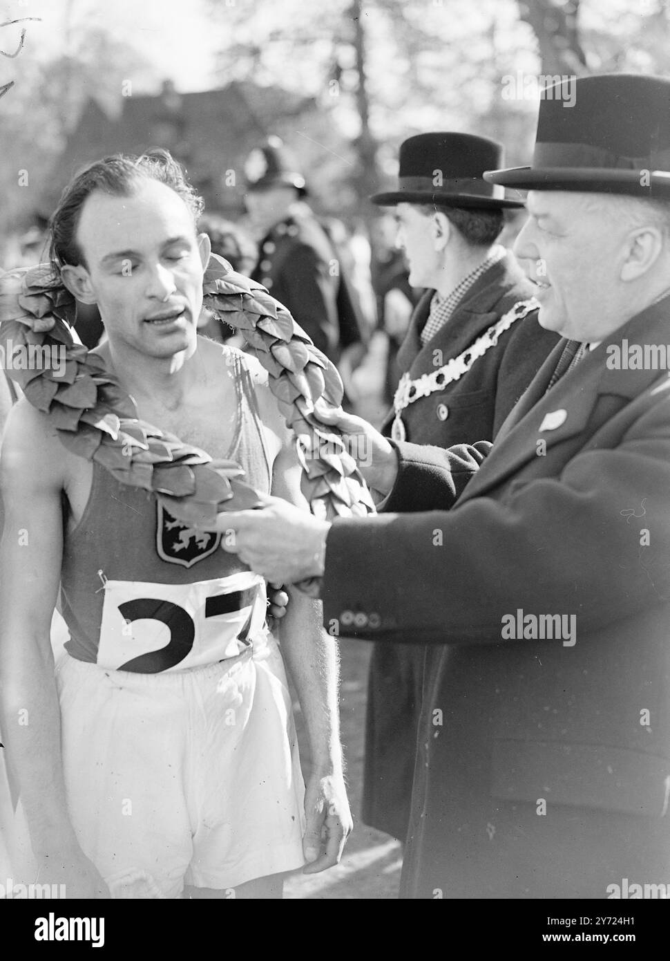 Inghilterra (114) punti) sono stati un brutto 3° 2 Belgio (46) e Francia (47) nella gara internazionale di cross country a Redding questo pomeriggio (sabato). J. DOMS (Belgio) è stato il primo uomo a casa in 54 minuti e 5,4 secondi, e il primo rappresentante inglese a finire è stato e Donner (55 minuti e 17 secondi) Sydney Wooderson, che ha corso bene all'inizio della gara è caduto più tardi per finire 14° in 55 minuti e 50 secondi. L'immagine mostra: Una J. DOMS (Belgio) riceve oggi la corona di alloro di vittoria da W. C. Jewell, presidente dell'unione internazionale di cross-country a Redding. 5 aprile 1948 Foto Stock