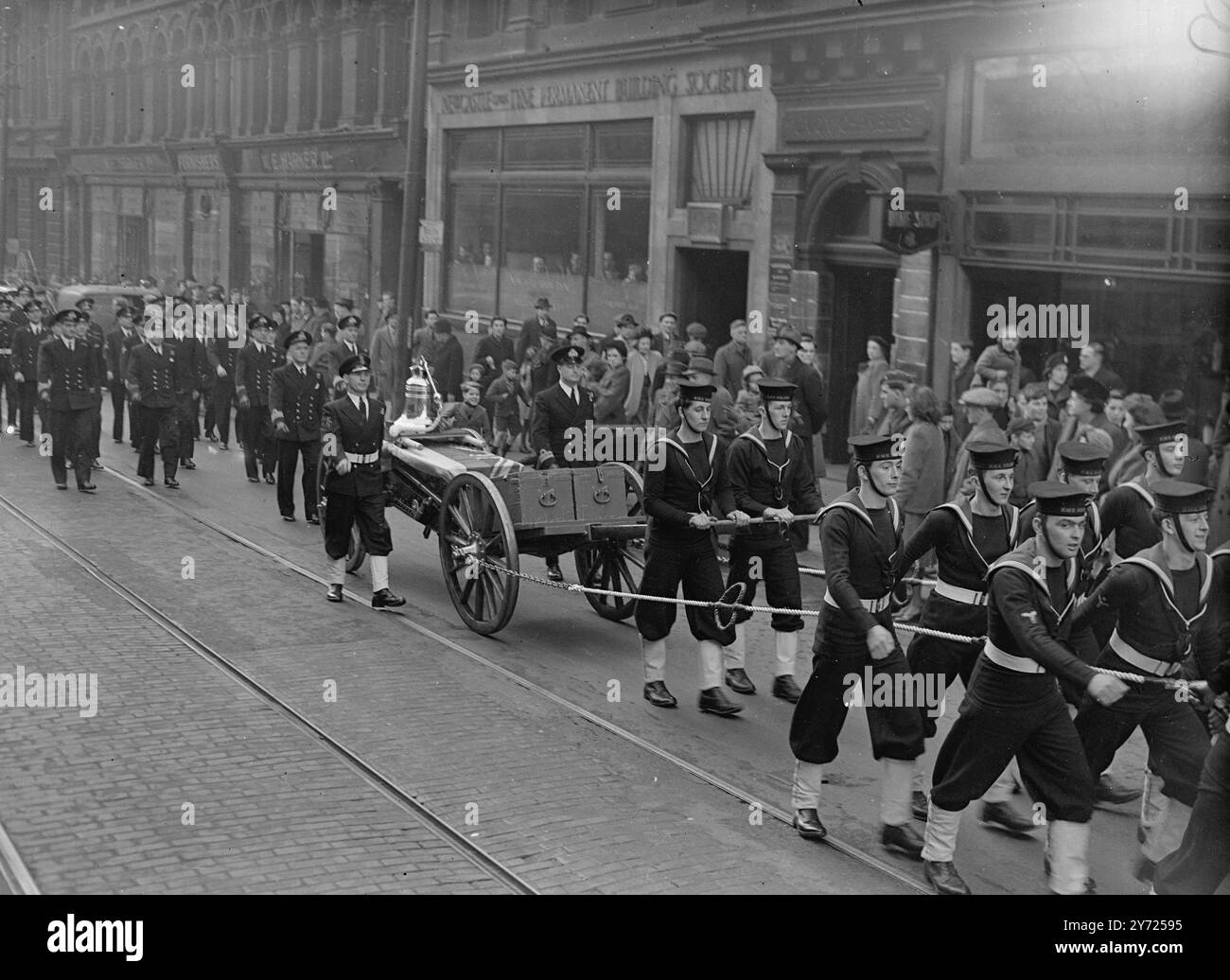 "Nelson's Bell" la campana della nave di H.M.S Nelson, la famosa nave ammiraglia della Home Fleet che deve essere demolita, è stata presentata alla gente di Newcastle-on-Tyne dove è stata costruita nel 1922. Le immagini mostrano: La campana del Nelson è trasportata su un carrlage di cannoni con scorta navale per le strade di Newcastle, da presentare alla Newcastle Corporation. 18 febbraio 1948. Foto Stock
